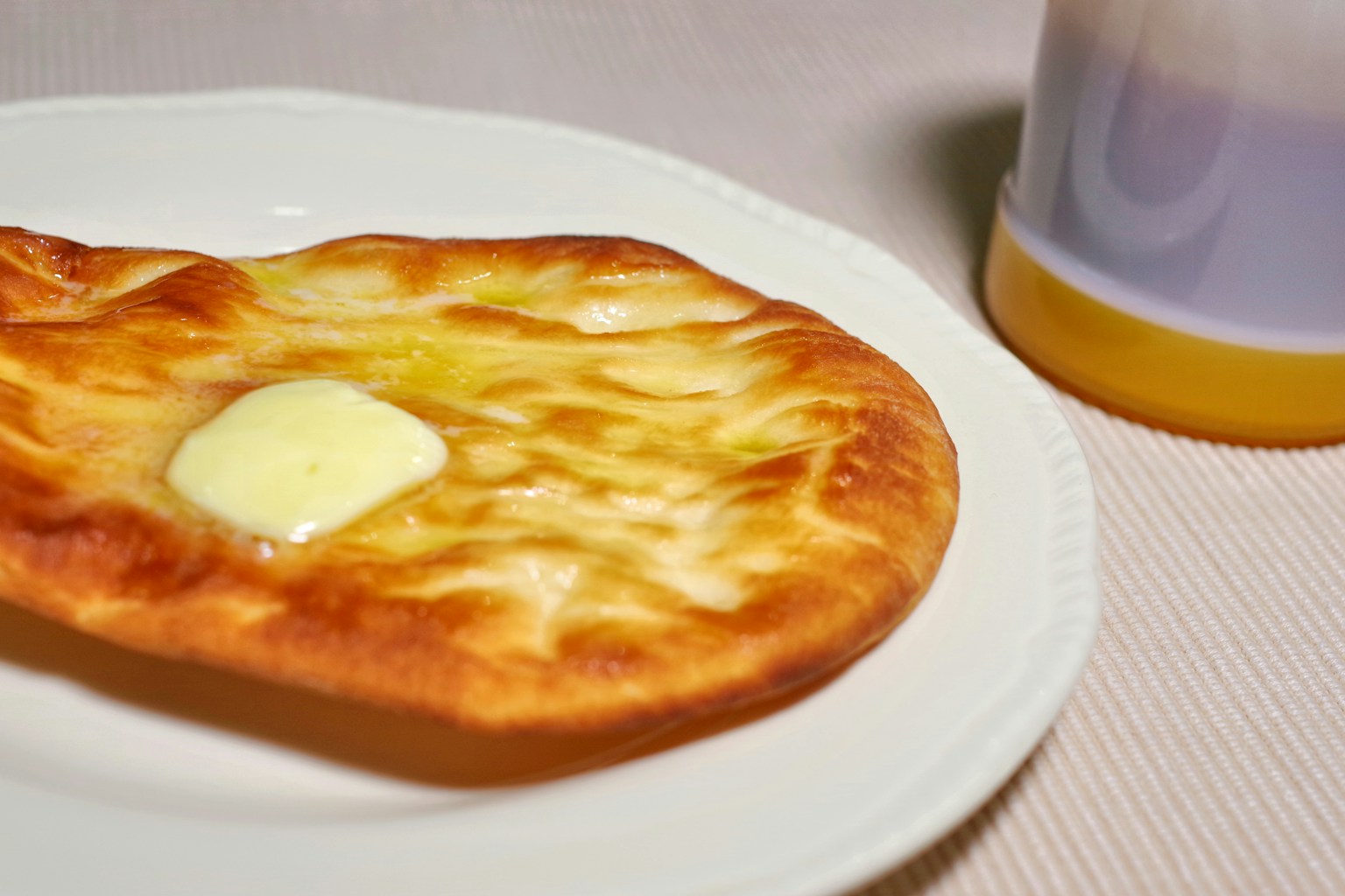 Freshly baked flatbread with butter on a white plate