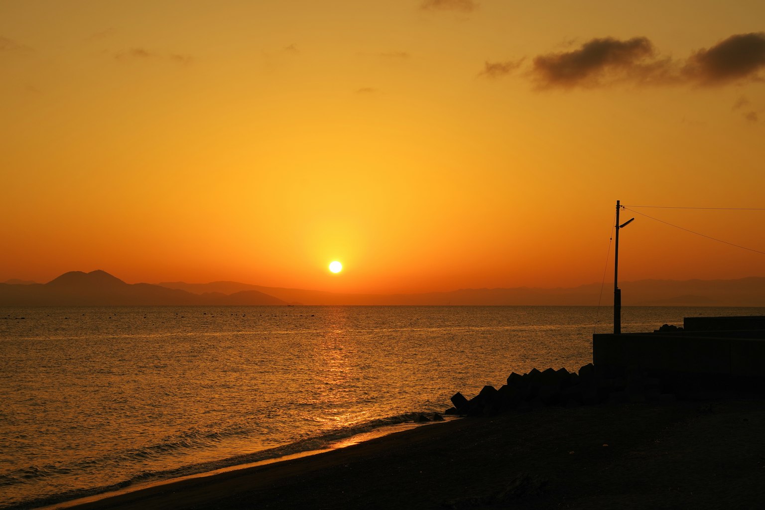 Schöner Sonnenuntergang über dem Ozean mit orangefarbenem Himmel und ruhigem Wasser