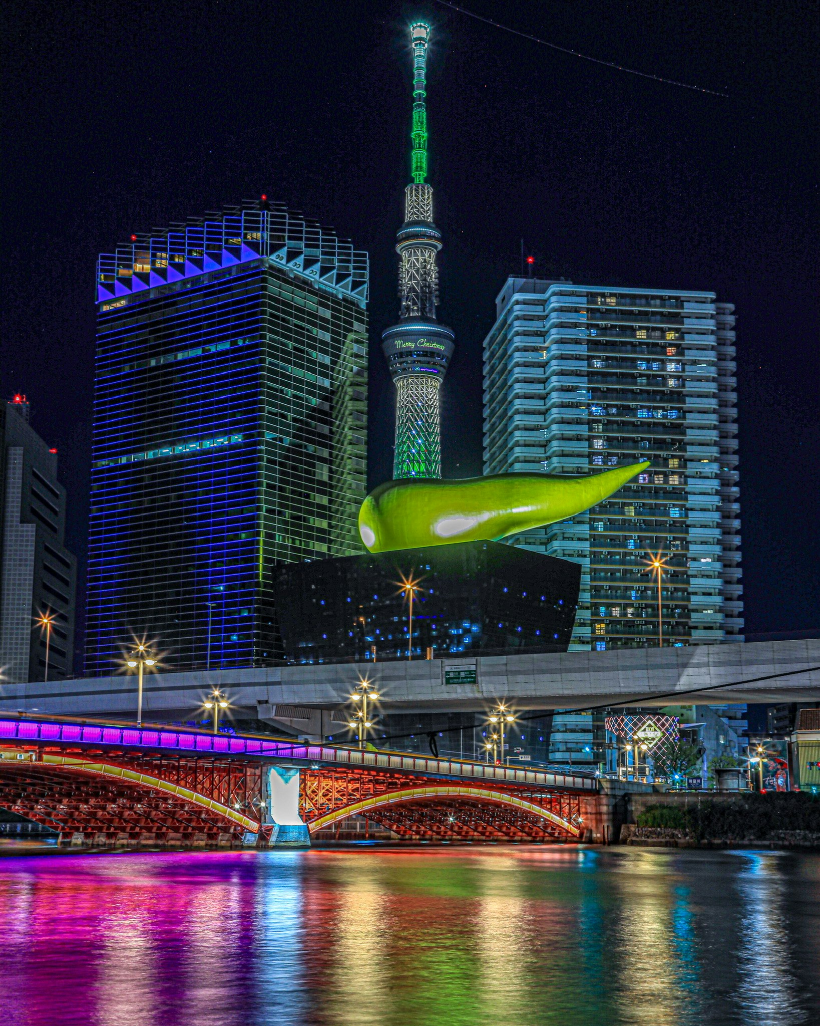 夜の水辺に映る東京スカイツリーと高層ビル群