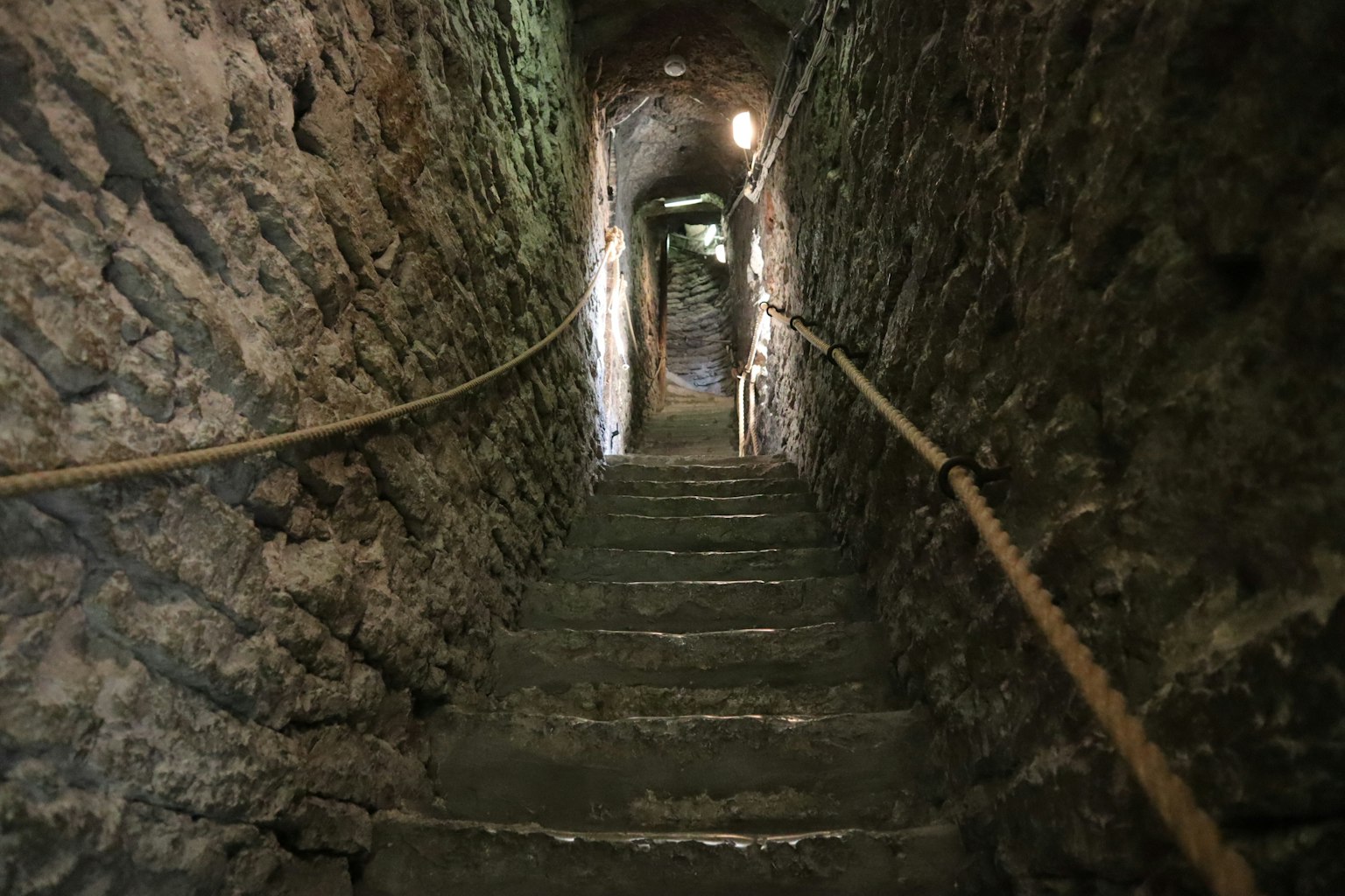 Interior of a dark tunnel with stone stairs and dim lighting