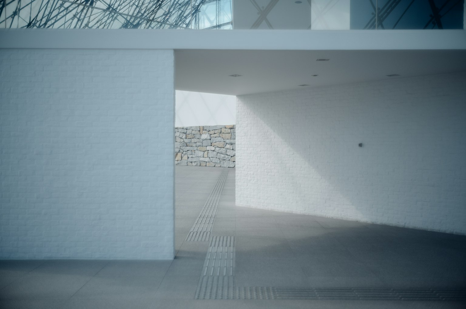 Modern architectural space with intersecting white and stone walls