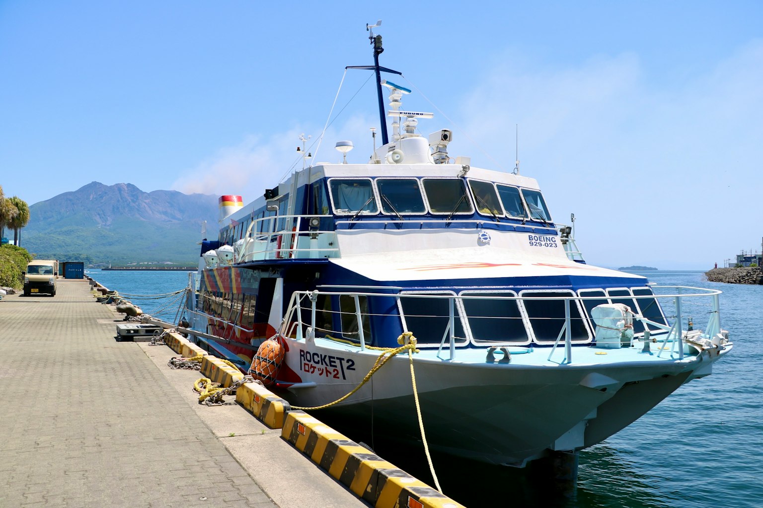 Ferry colorato ormeggiato nel porto con montagne sullo sfondo