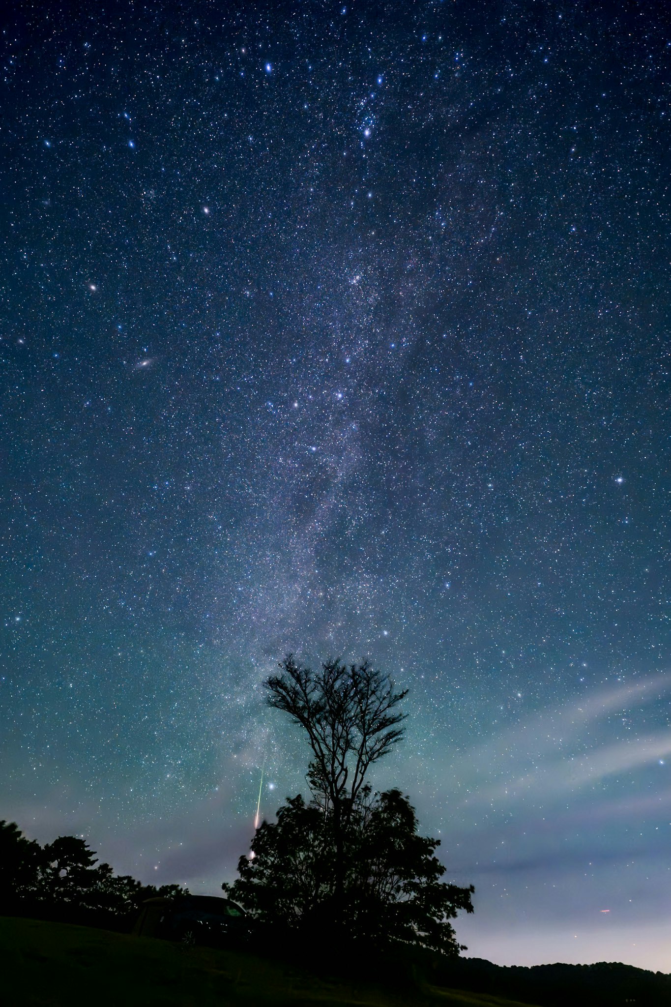 Via Lattea e cielo stellato sopra un paesaggio scuro