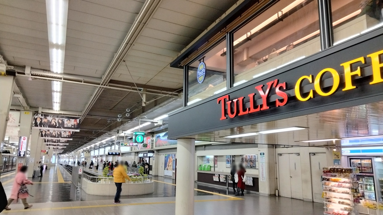 Cảnh nội thất của ga có biển hiệu Tully's Coffee và hành khách