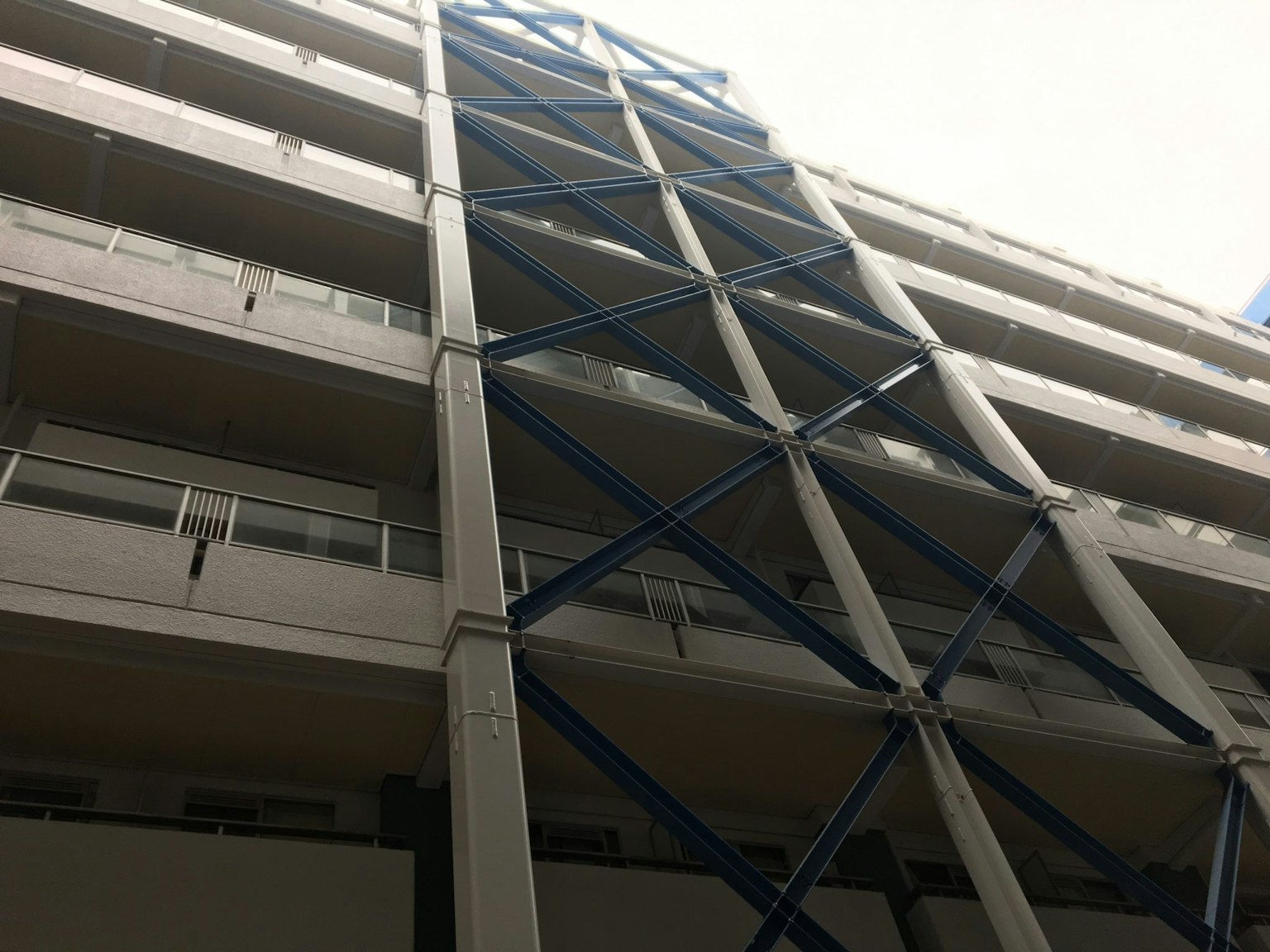 Modern building exterior featuring distinctive blue steel supports
