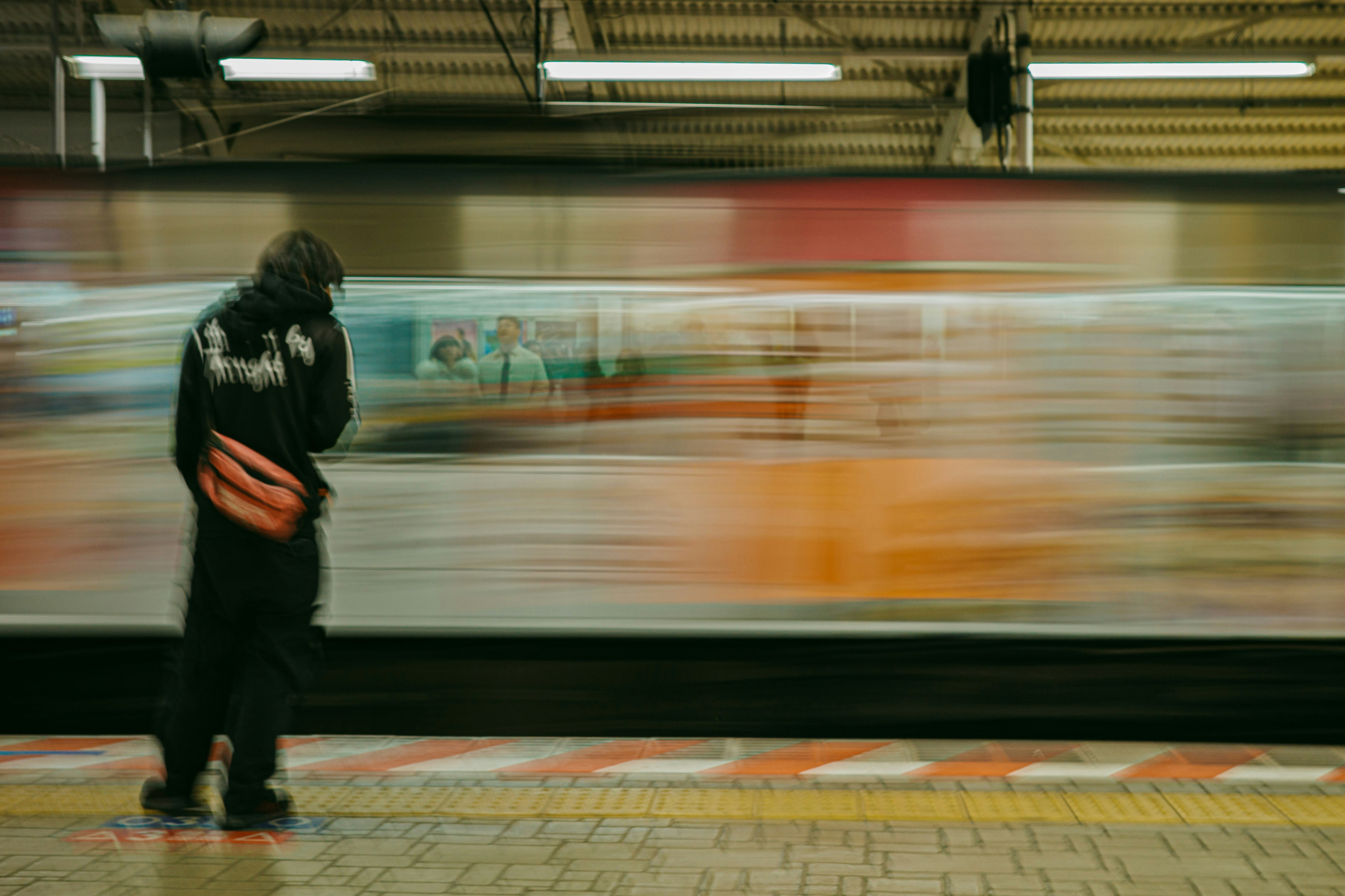 駅のホームで手をつないで歩く人の流し撮り