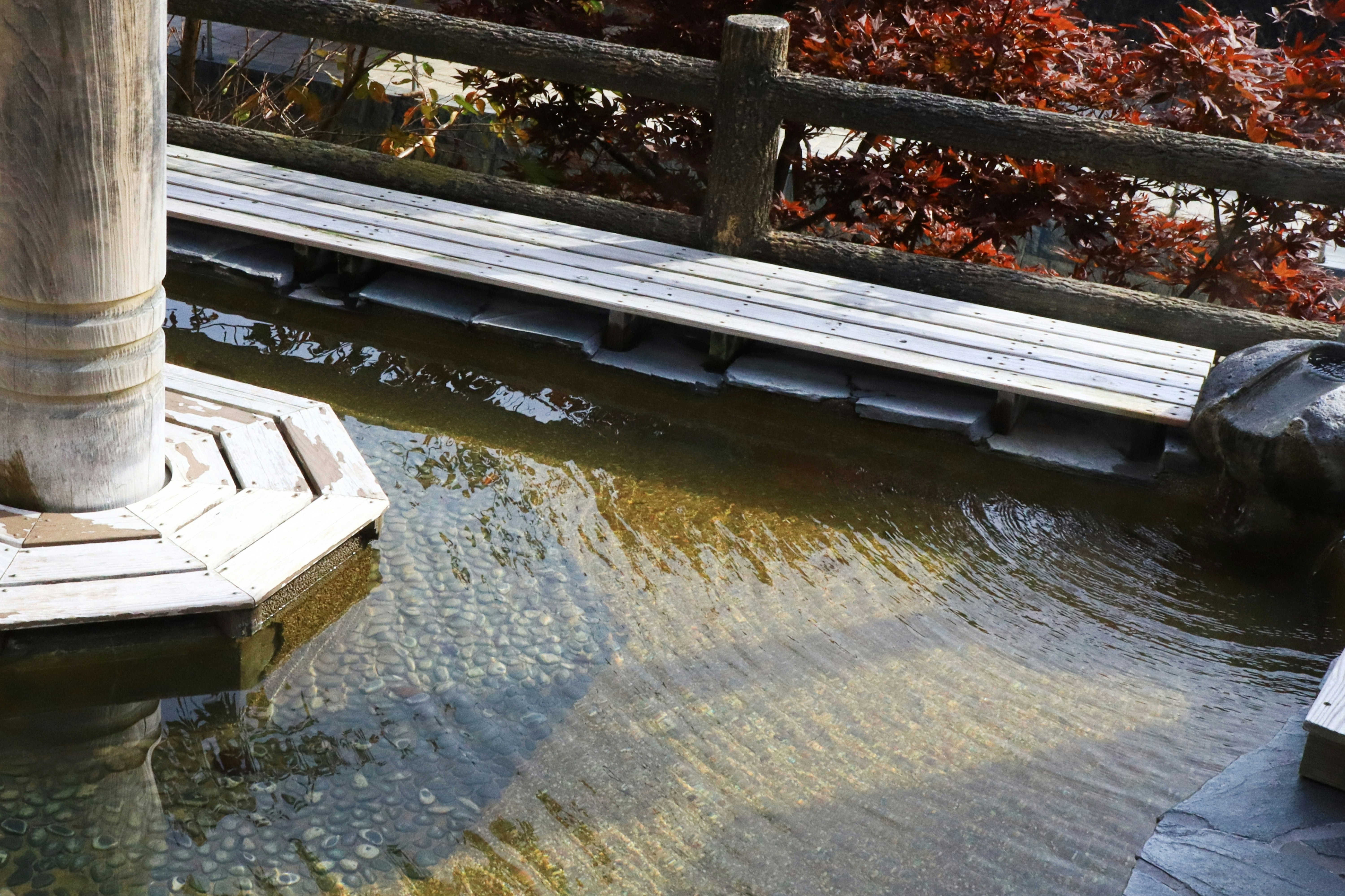 石積みの水路に流れる川と木製の柵