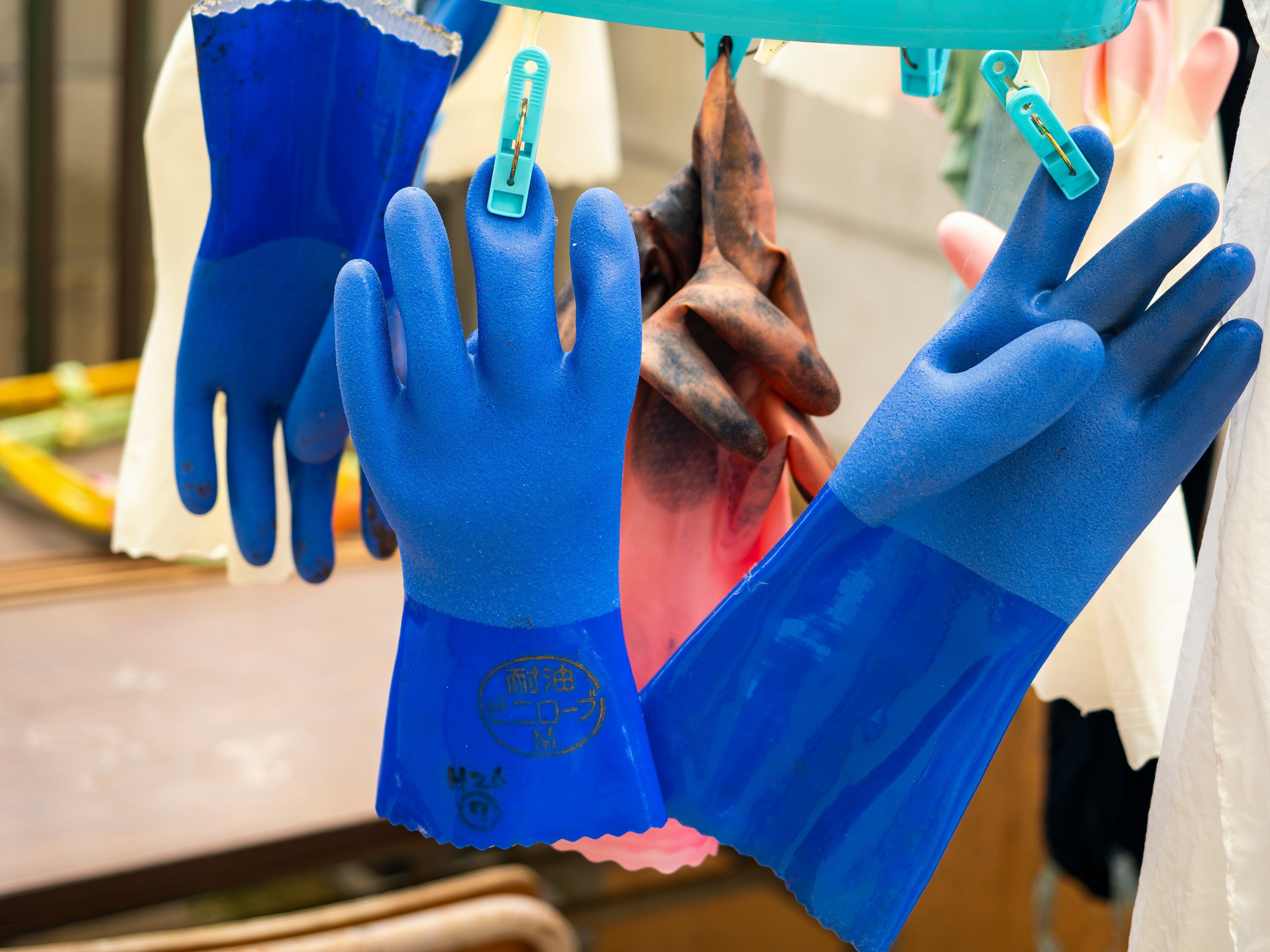 guantes de goma azules colgados para secar