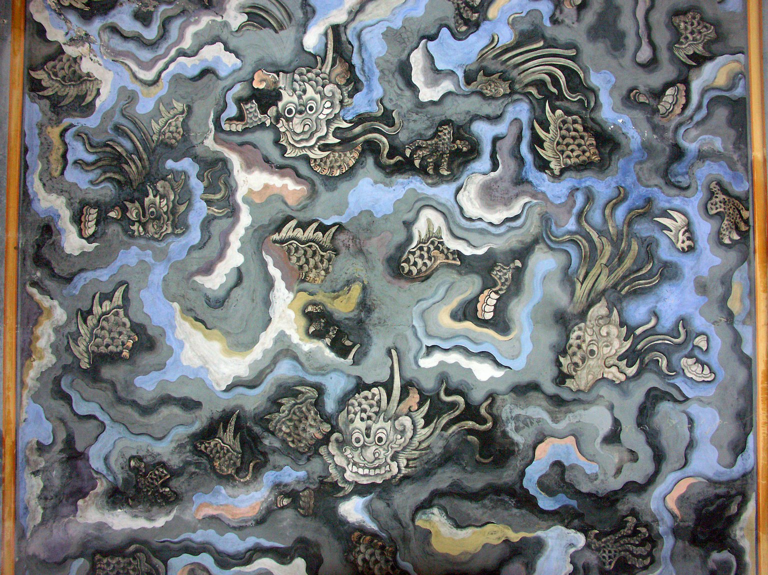 Art piece featuring swirling patterns in blue and black with fish shapes