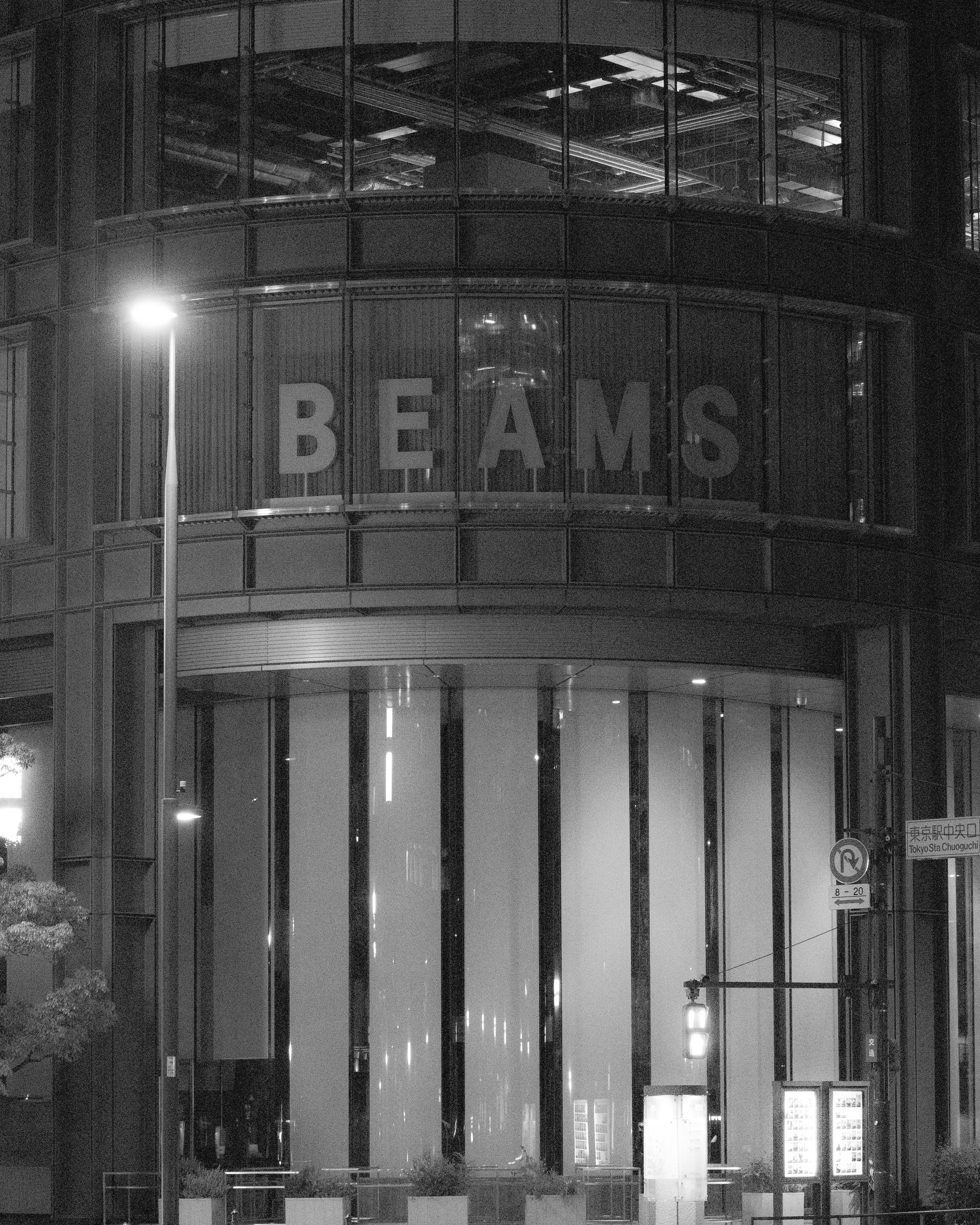 Entrada de edificio de noche con letrero « BEAMS »