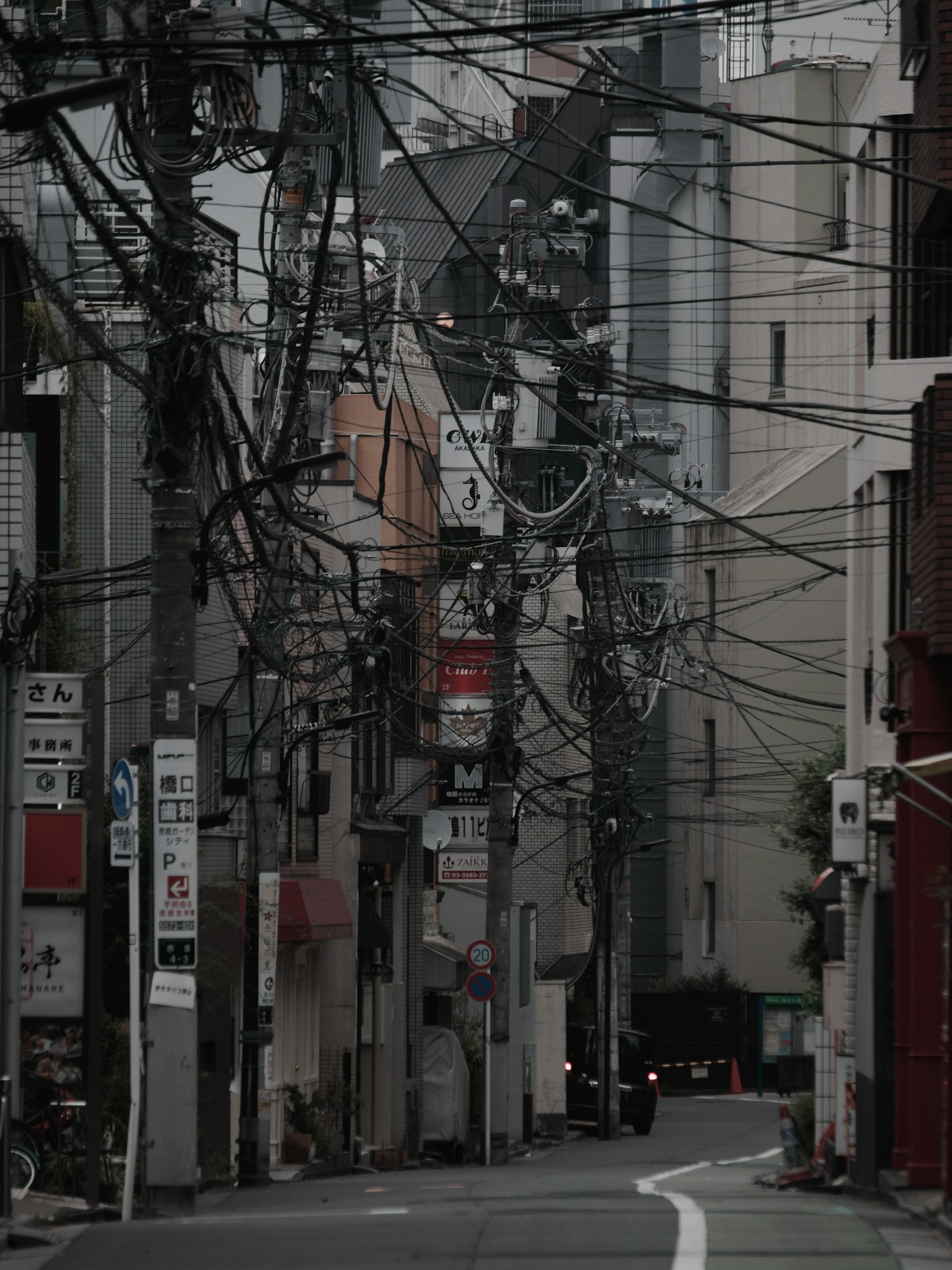 Jalan sempit dengan kabel listrik yang kusut dan bangunan