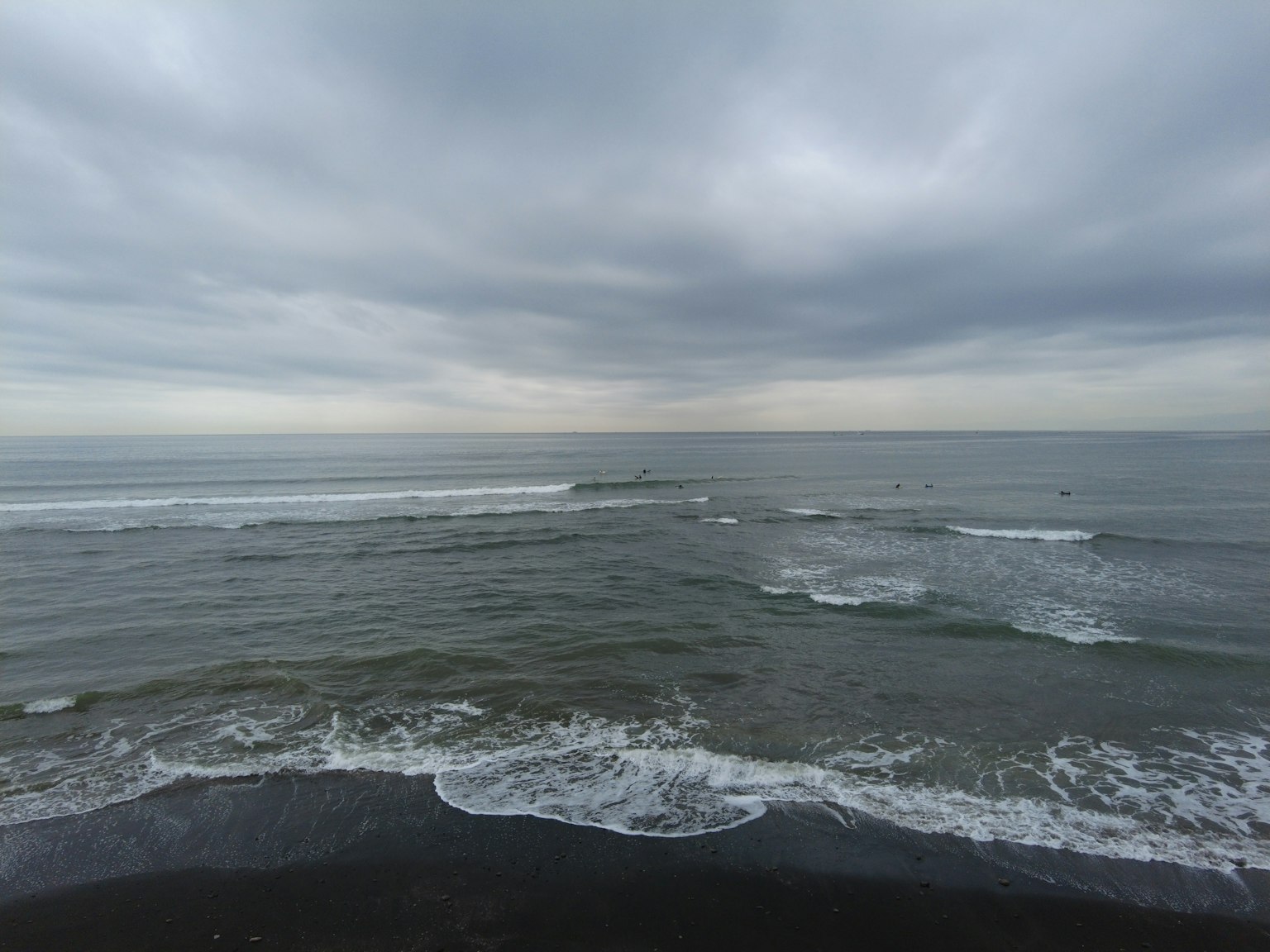 Vue côtière avec des vagues sous un ciel nuageux