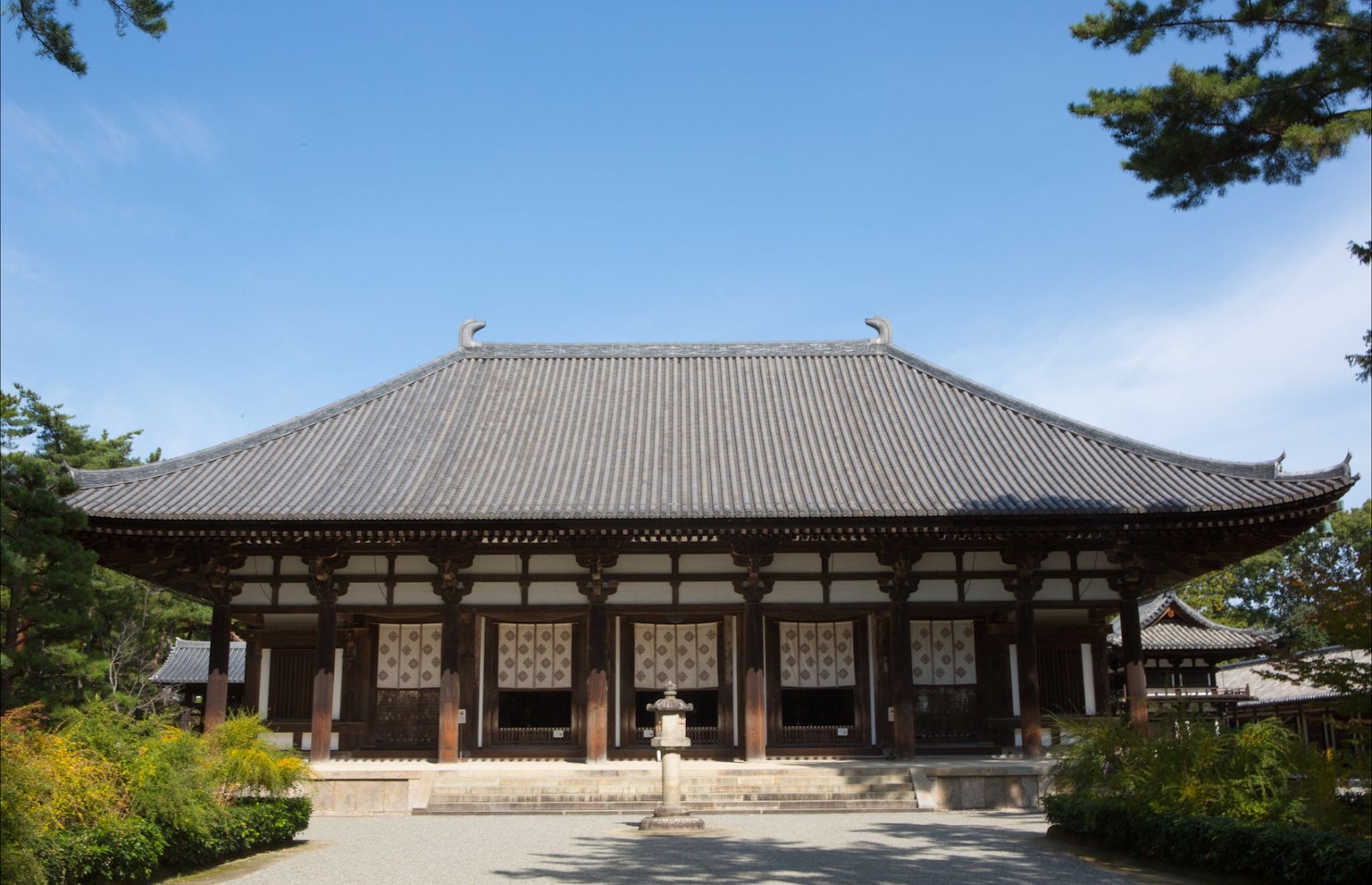 Bel extérieur d'un temple japonais entouré de jardins luxuriants et d'un ciel bleu