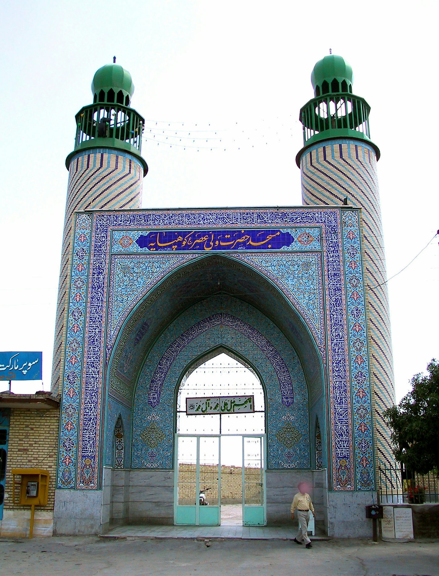 Ingresso di una bella moschea con decorazioni in piastrelle blu e verdi e due minareti