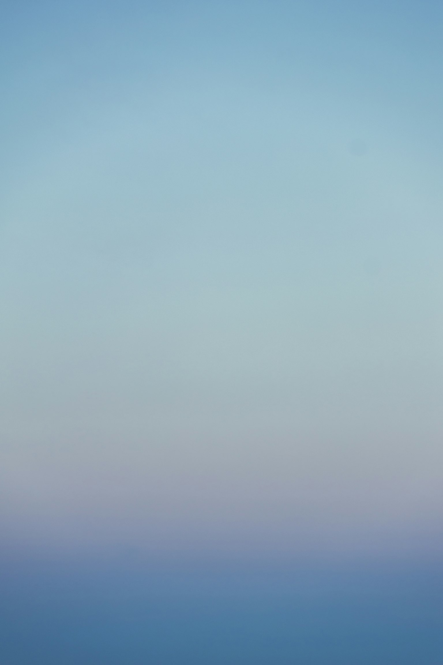 Un dégradé de couleurs douces dans le ciel passant du bleu à des teintes claires