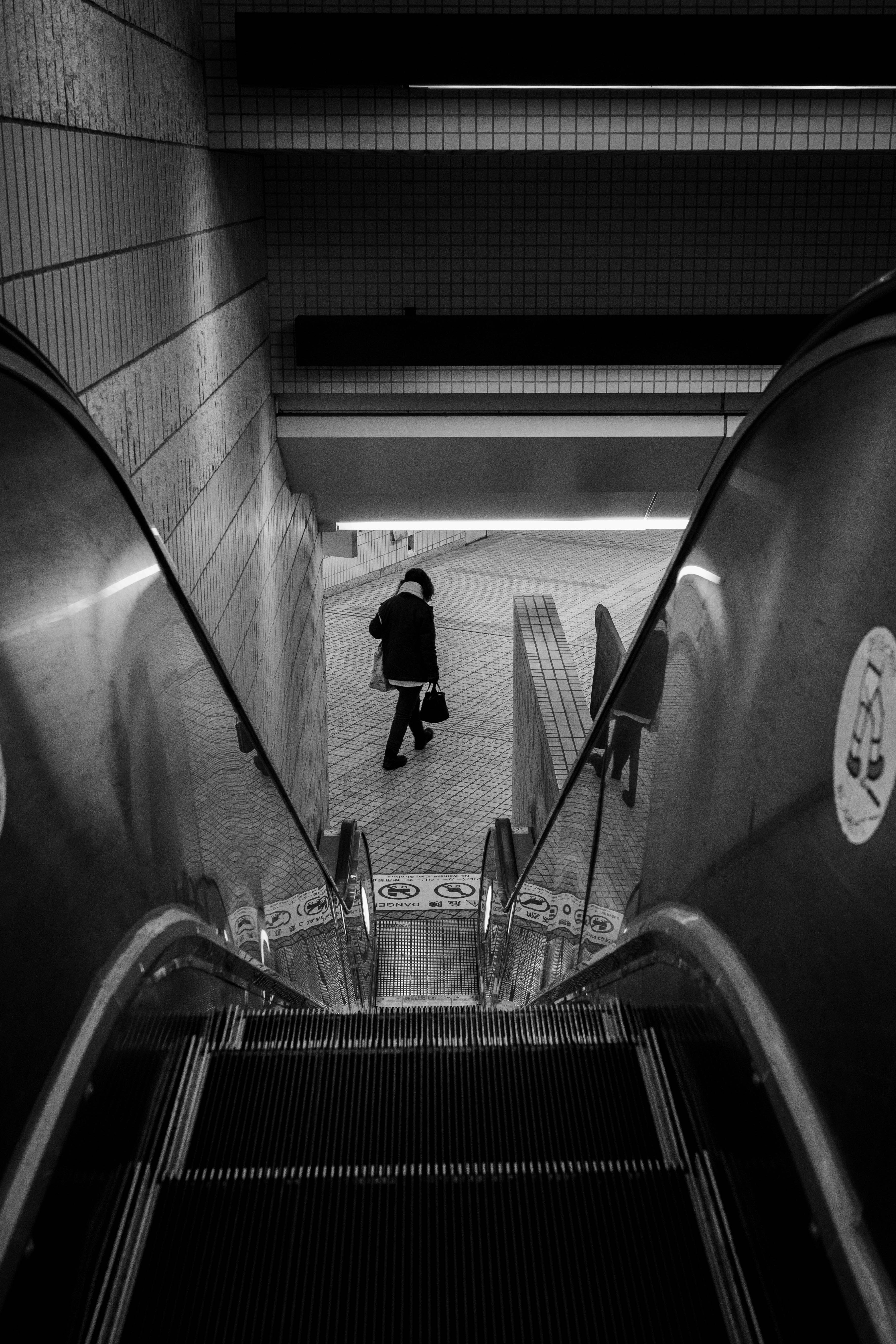 アーチ状の通路を歩く人物のストリートスナップ