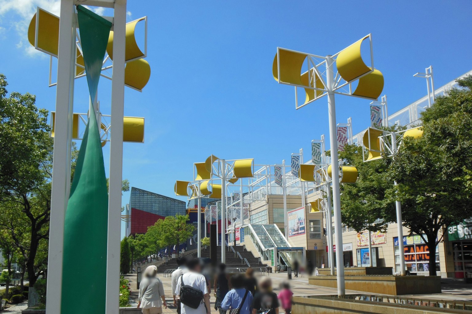 Park scene with yellow wind turbines under a blue sky