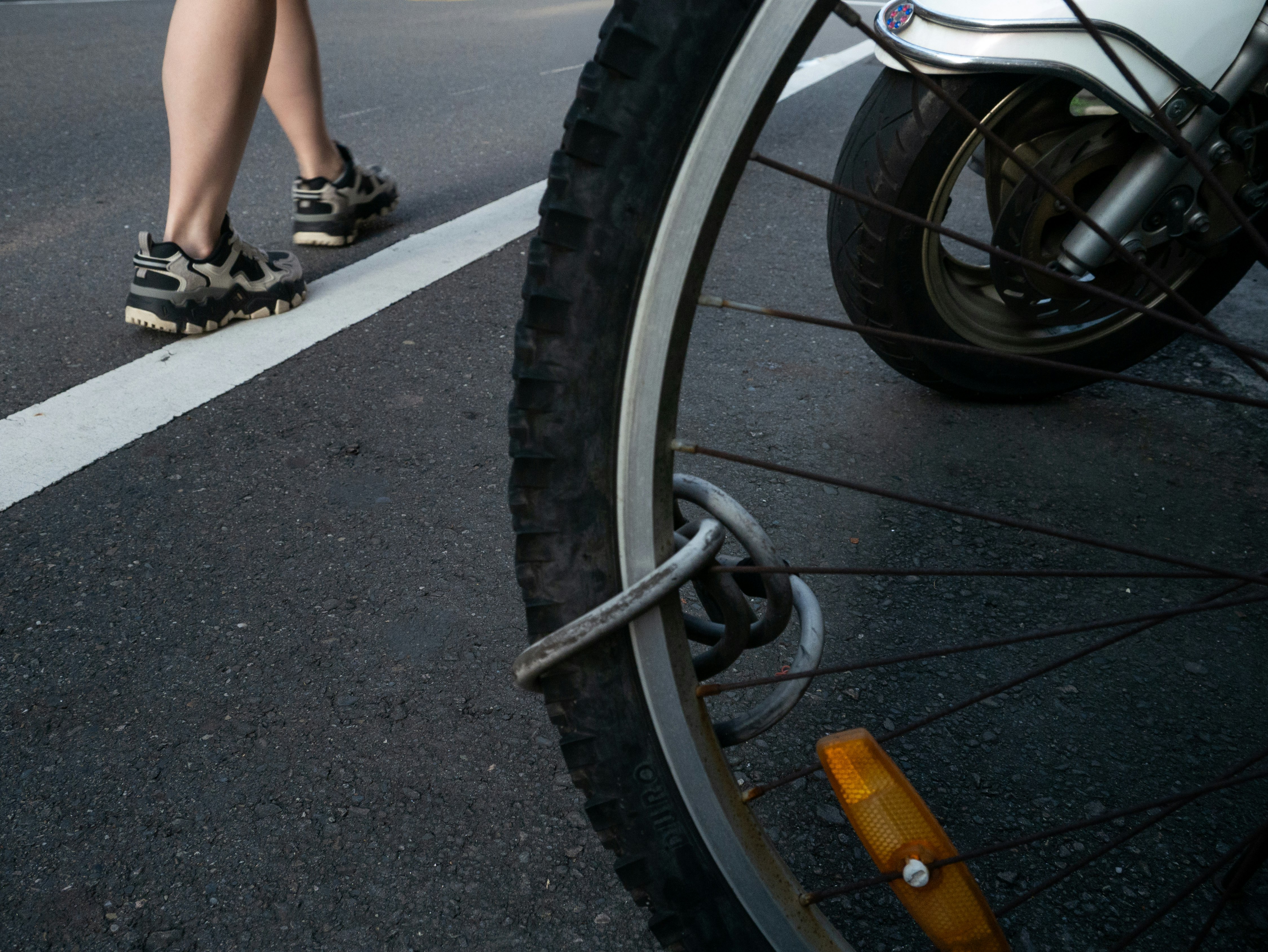 自転車の車輪と路上の歩行者の足元