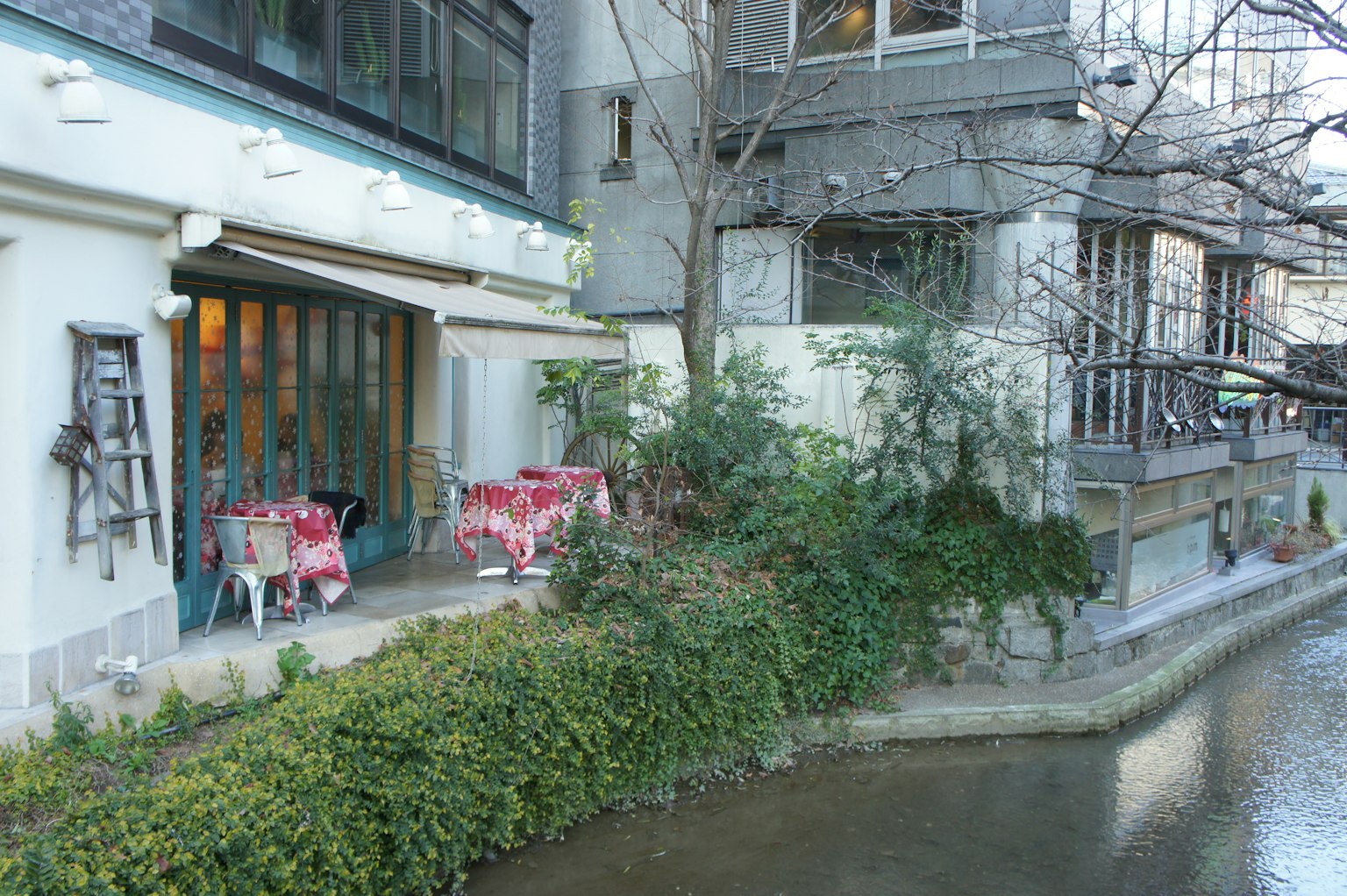 河邊咖啡館的露台，粉色桌子和綠色植物