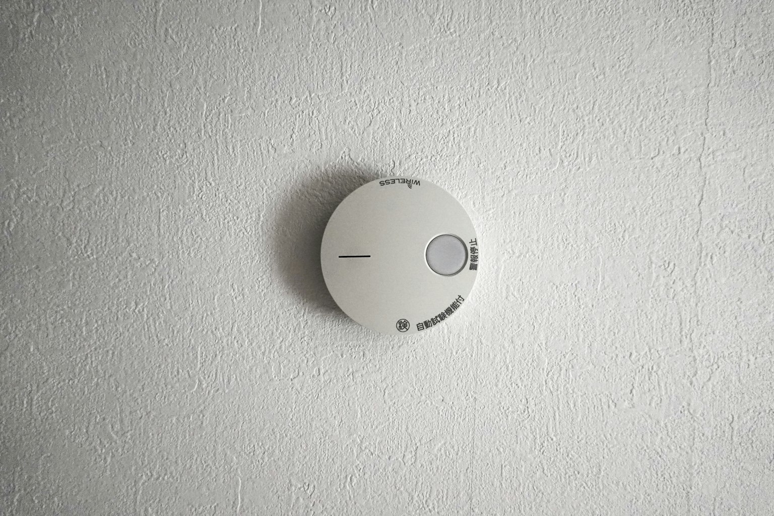 Runder Rauchmelder an einer weißen Wand montiert
