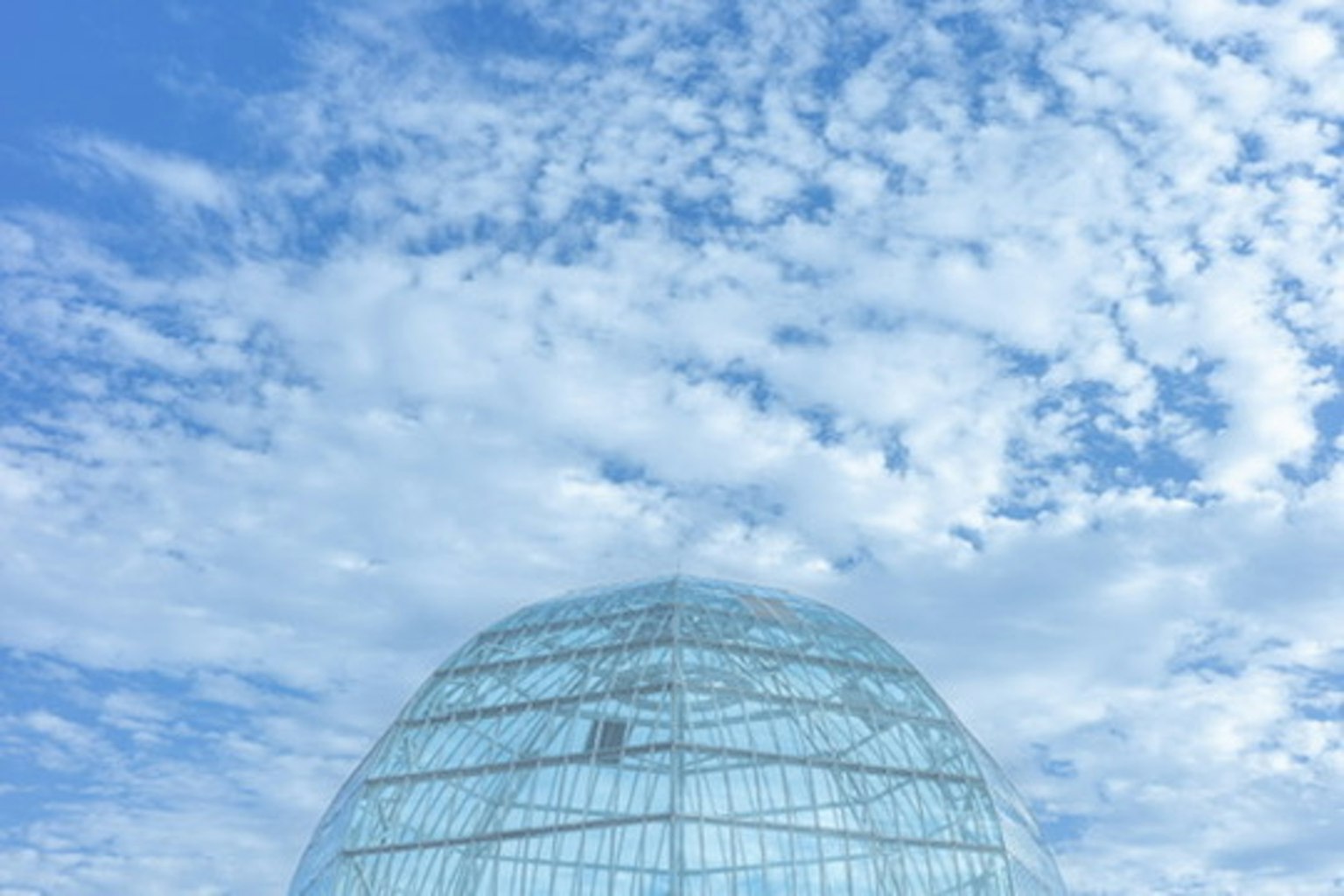 Cupola di vetro contro uno sfondo di cielo blu e nuvole bianche