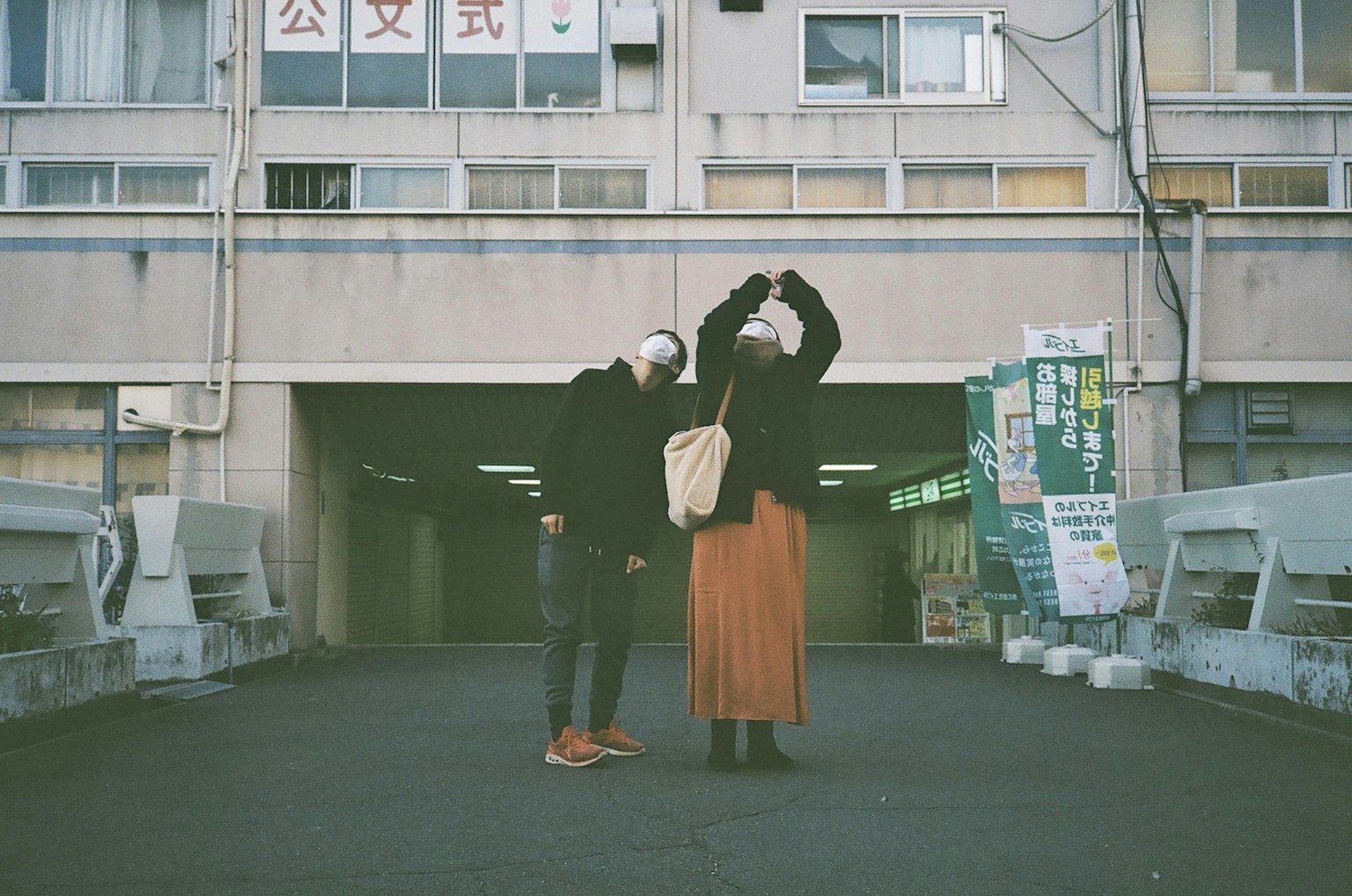 Hai người đang tạo dáng trong bối cảnh đô thị với nền là một tòa nhà