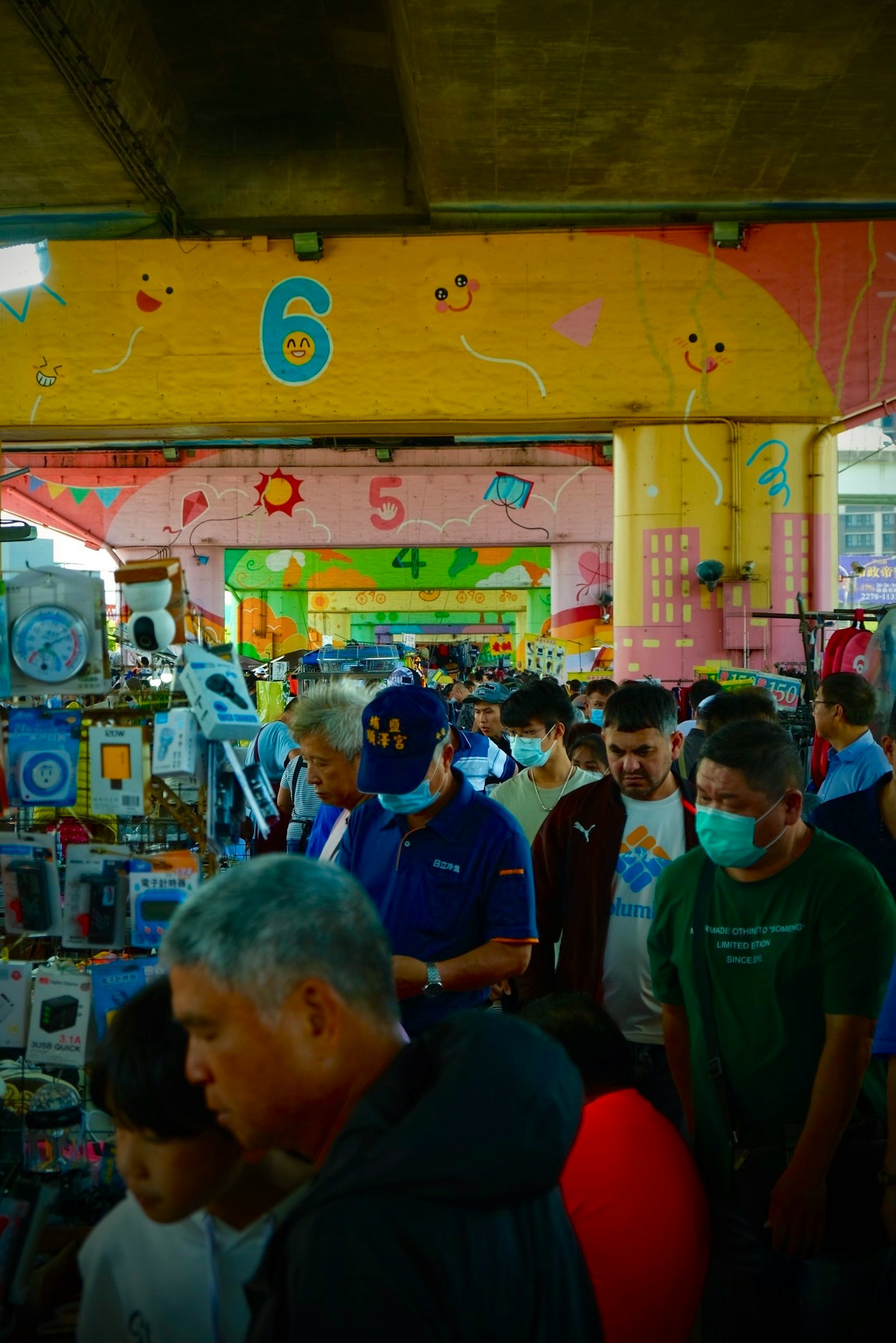Crowded market scene with colorful stalls and people browsing various products