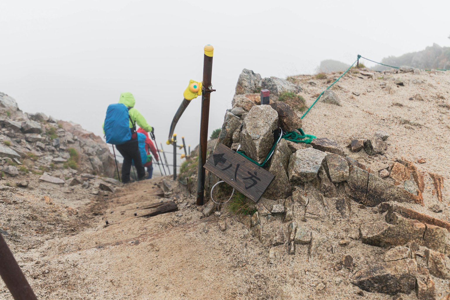在雾中下降的登山者和岩石小径