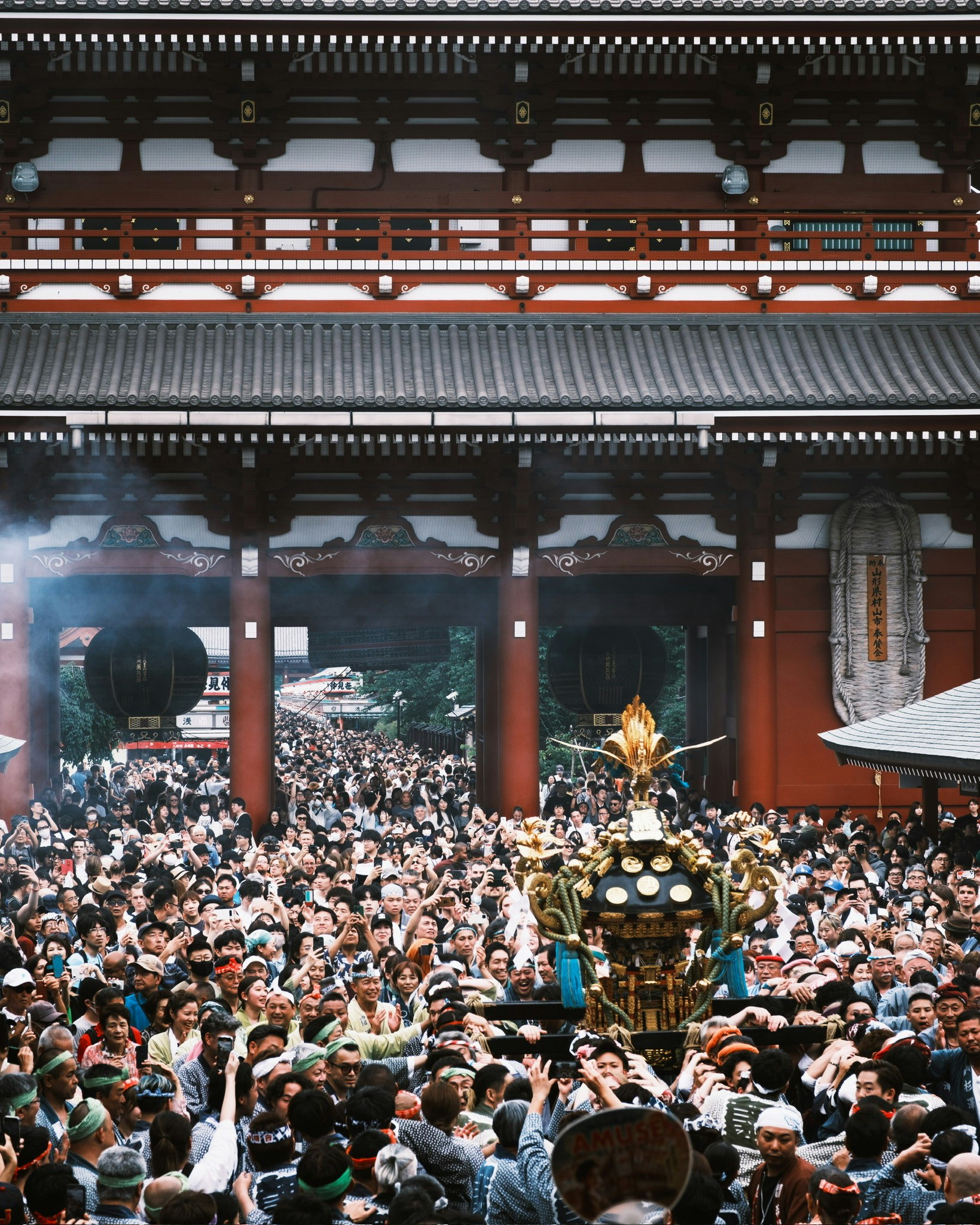 大勢の人が集まる寺院の門前と提灯のある参拝風景