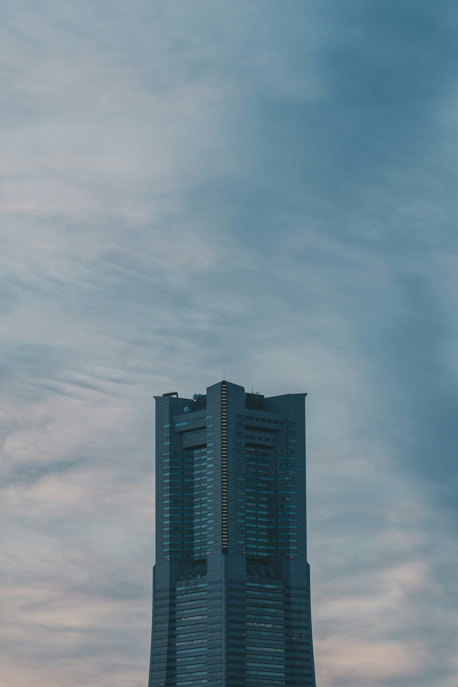 Modernes Hochhaus, das unter einem blauen Himmel ragt