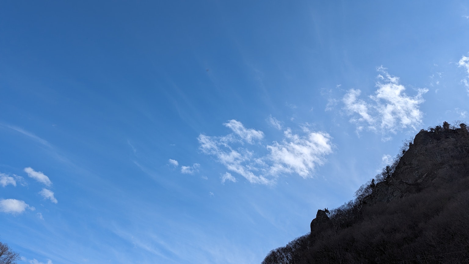 藍天與白雲的景觀，山的輪廓可見