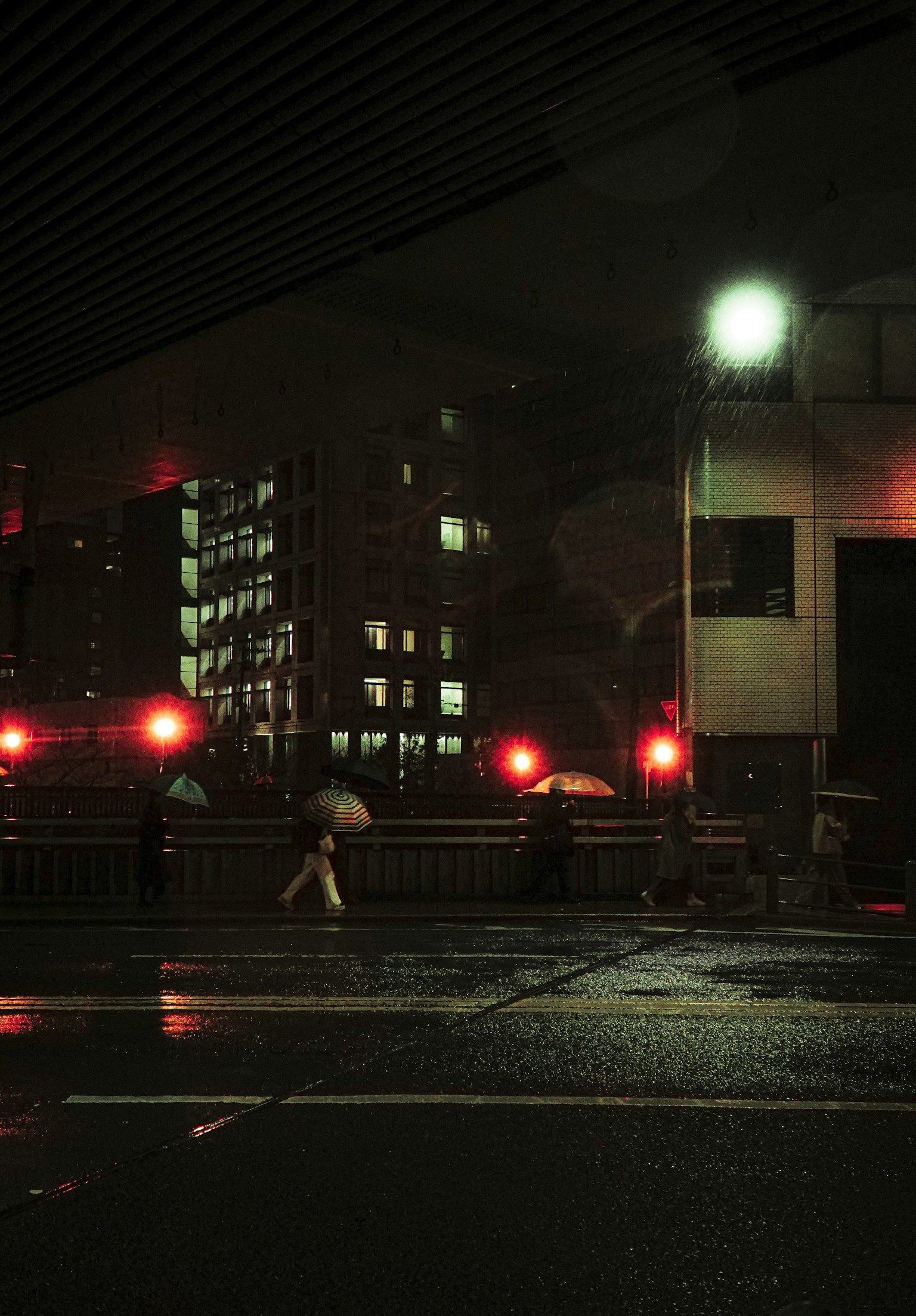 夜間城市景觀 雨濕的道路 紅色街燈和行人