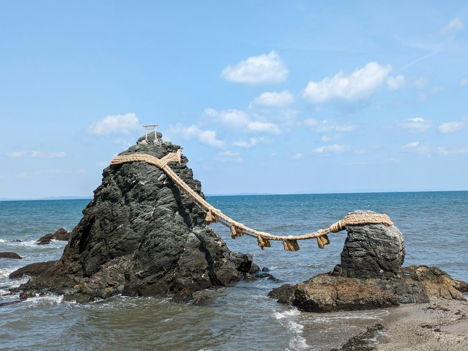 Rochers au bord de la mer avec un pont shimenawa les reliant