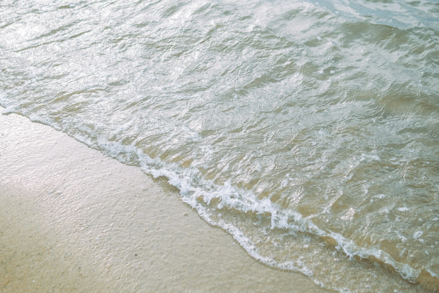 Vagues calmes se brisant sur une plage de sable