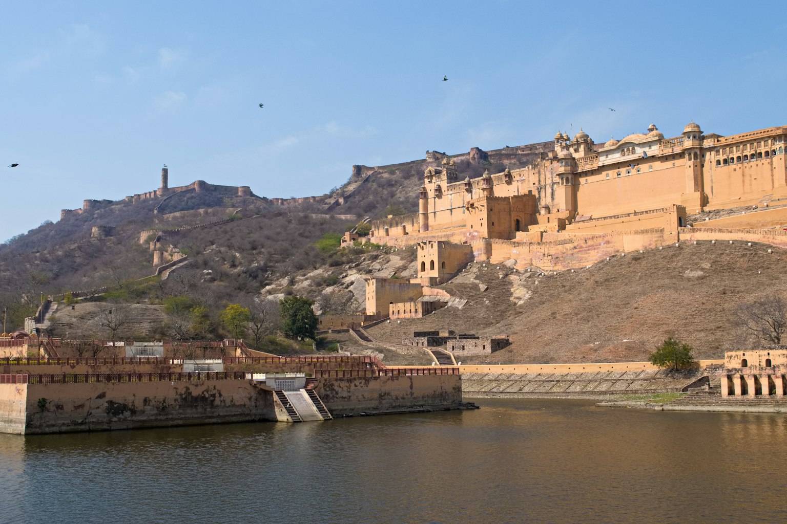 Amber Fort mit Blick auf einen See und historische Architektur und Hügel