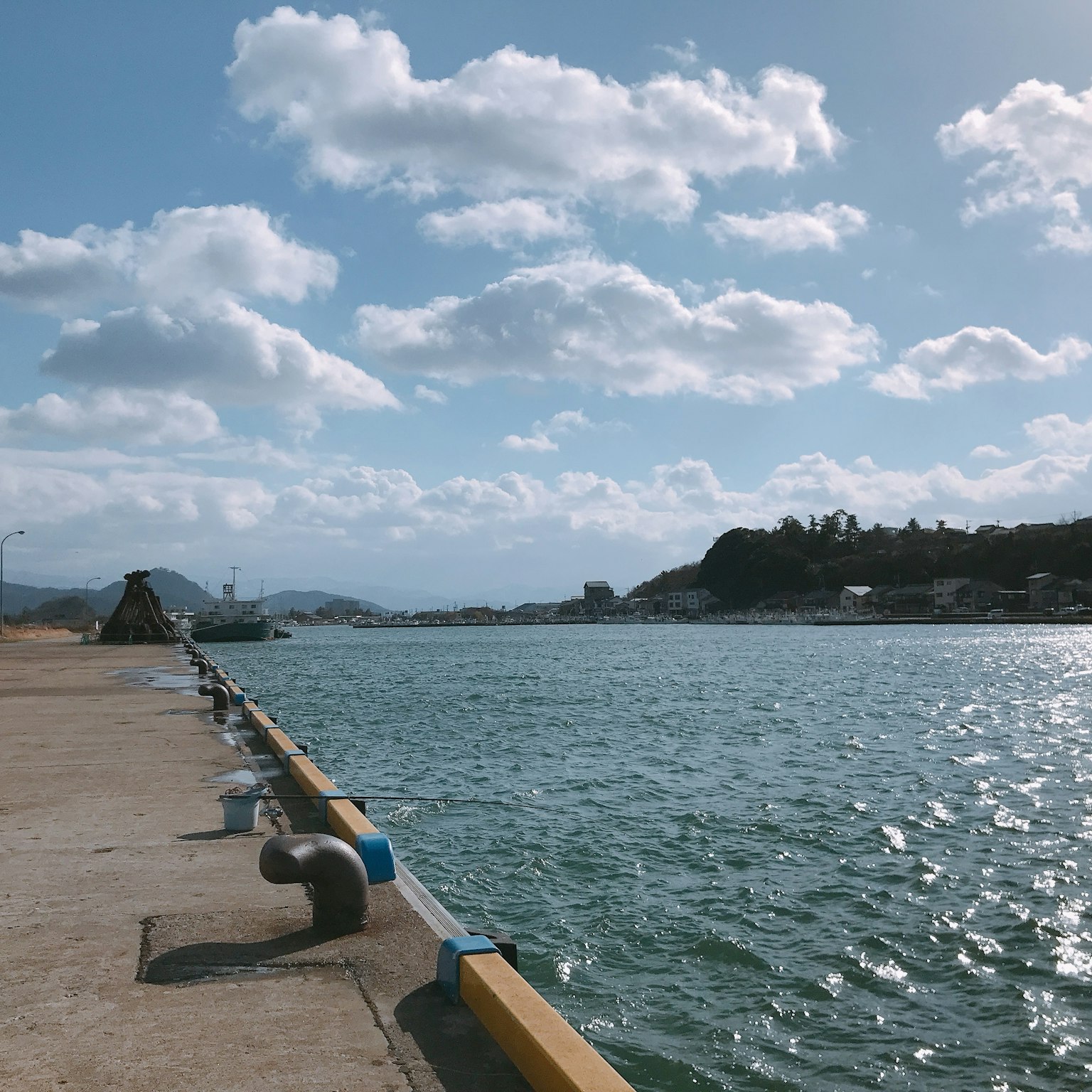 Scenic view of blue sea and white clouds at the harbor