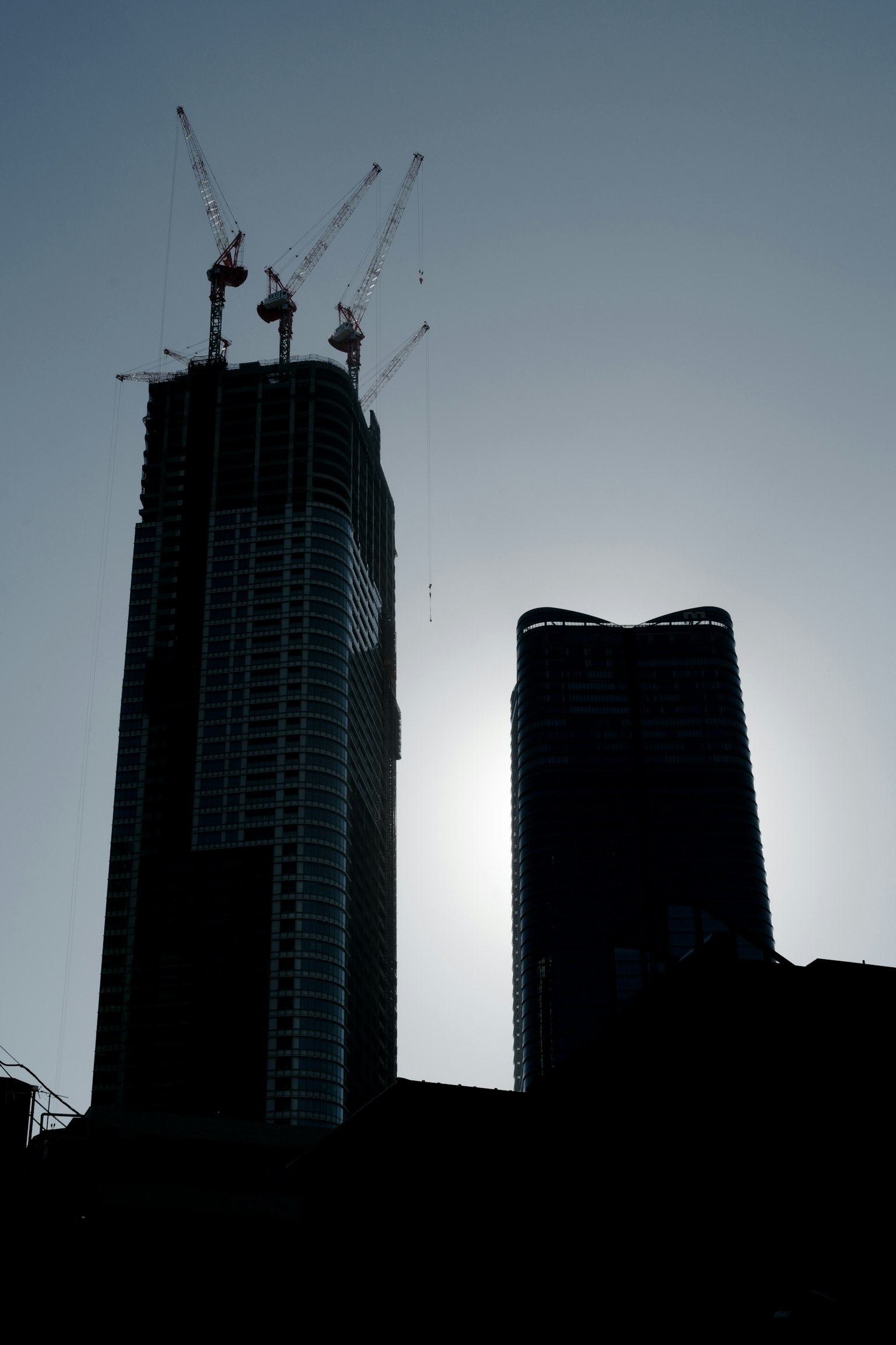 Silhouette de gratte-ciels en construction sur fond de soleil