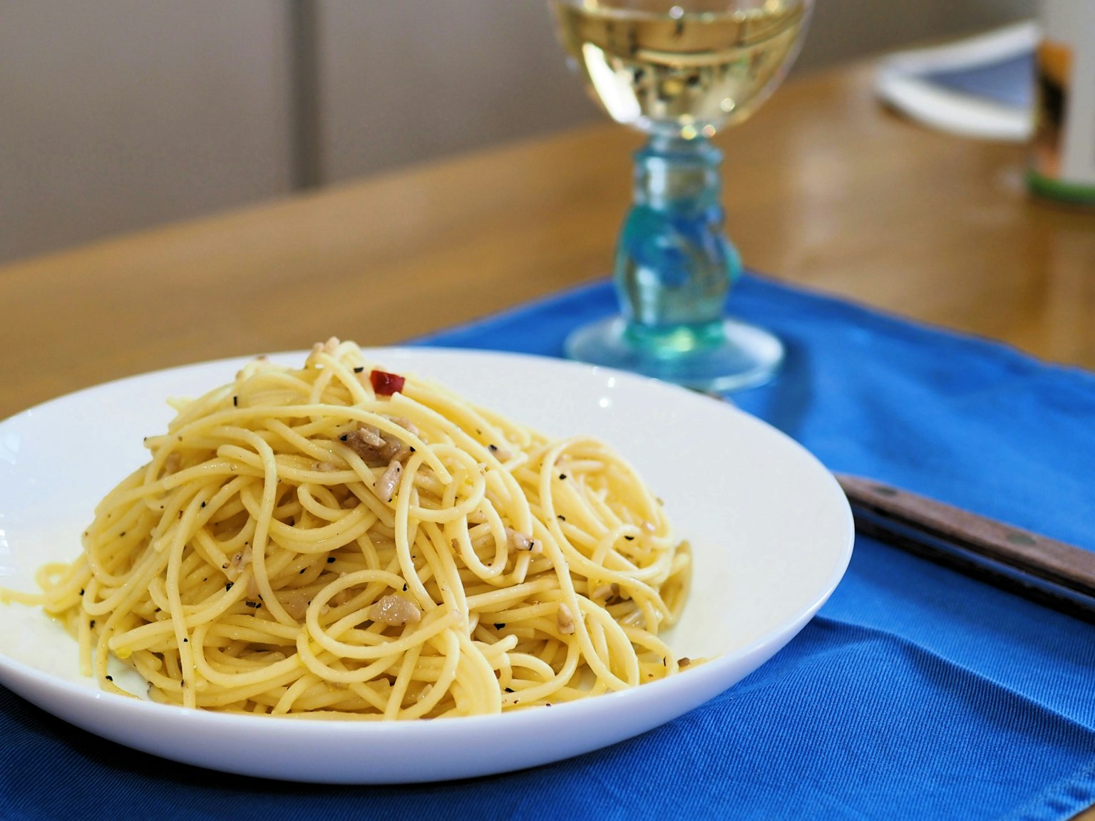 Teller mit Spaghetti und einem Glas Weißwein