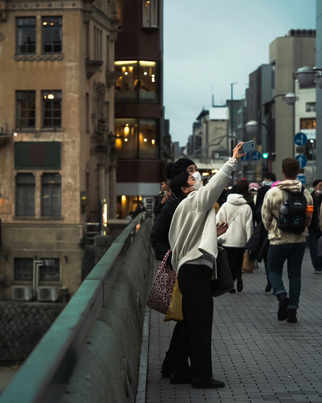 路地のような街並みで手を伸ばす人々のスナップ