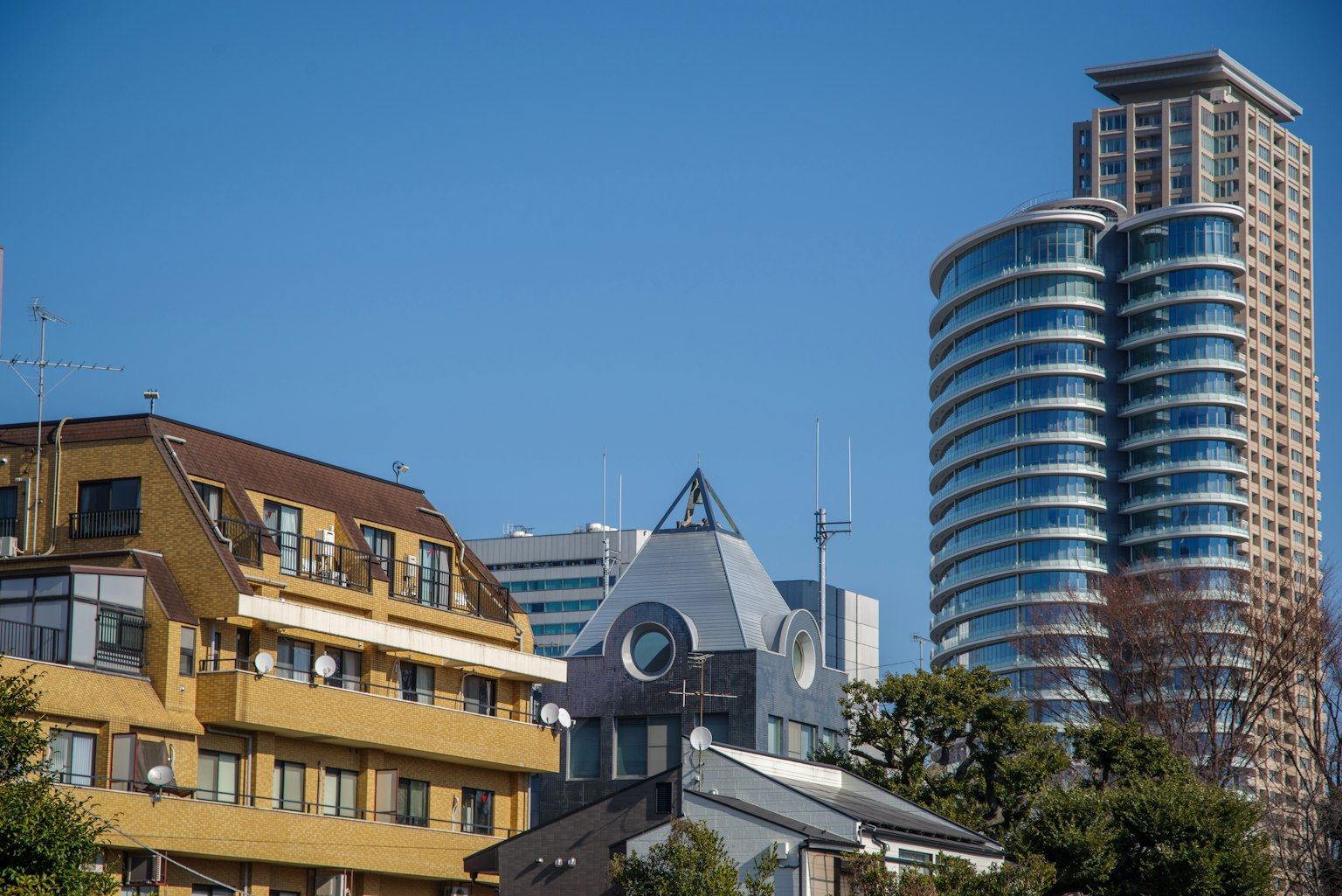 Urban landscape featuring modern skyscrapers and historical buildings under a clear blue sky