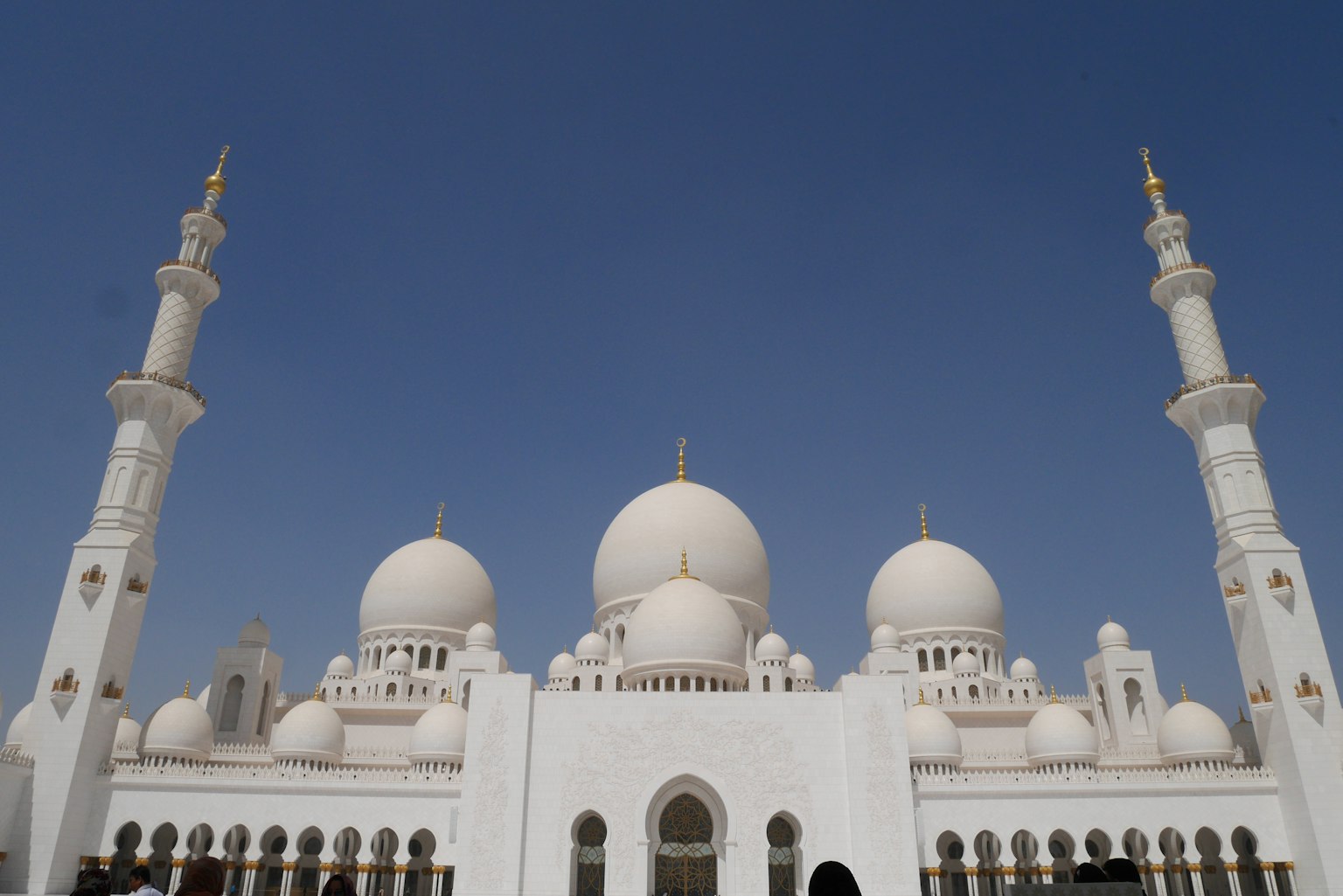 Extérieur majestueux d'une mosquée blanche avec des dômes et des minarets sur fond de ciel bleu