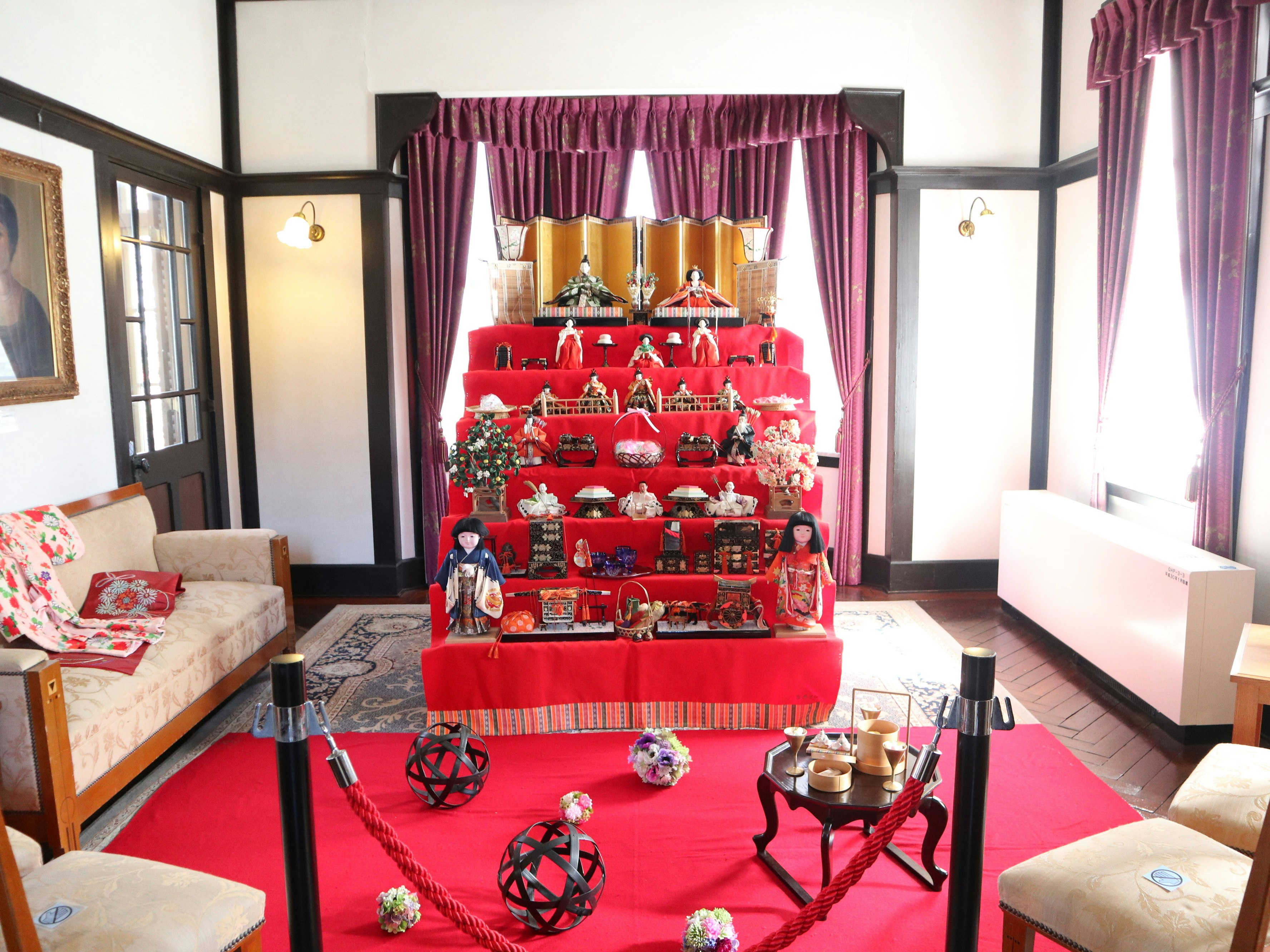 Dekorasi Hinamatsuri di dalam ruangan dengan boneka hina merah dan aksesori