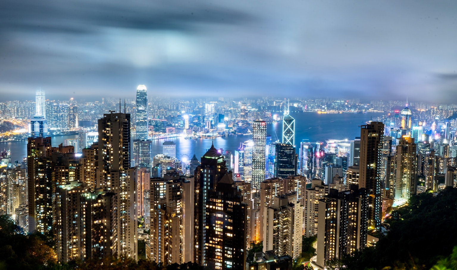 Impresionante vista nocturna del horizonte de Hong Kong con rascacielos y puerto