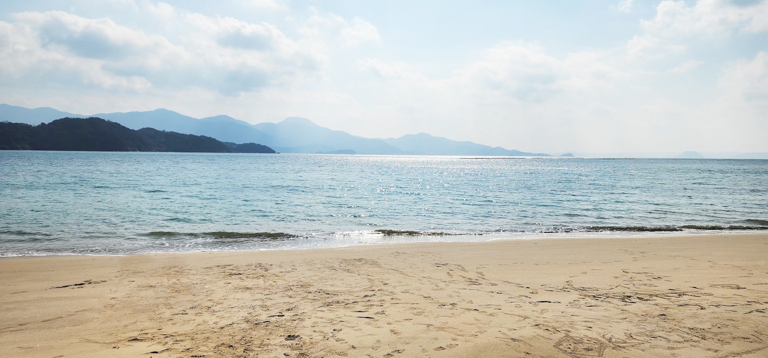 Scenic view of a tranquil beach with blue water and soft sand