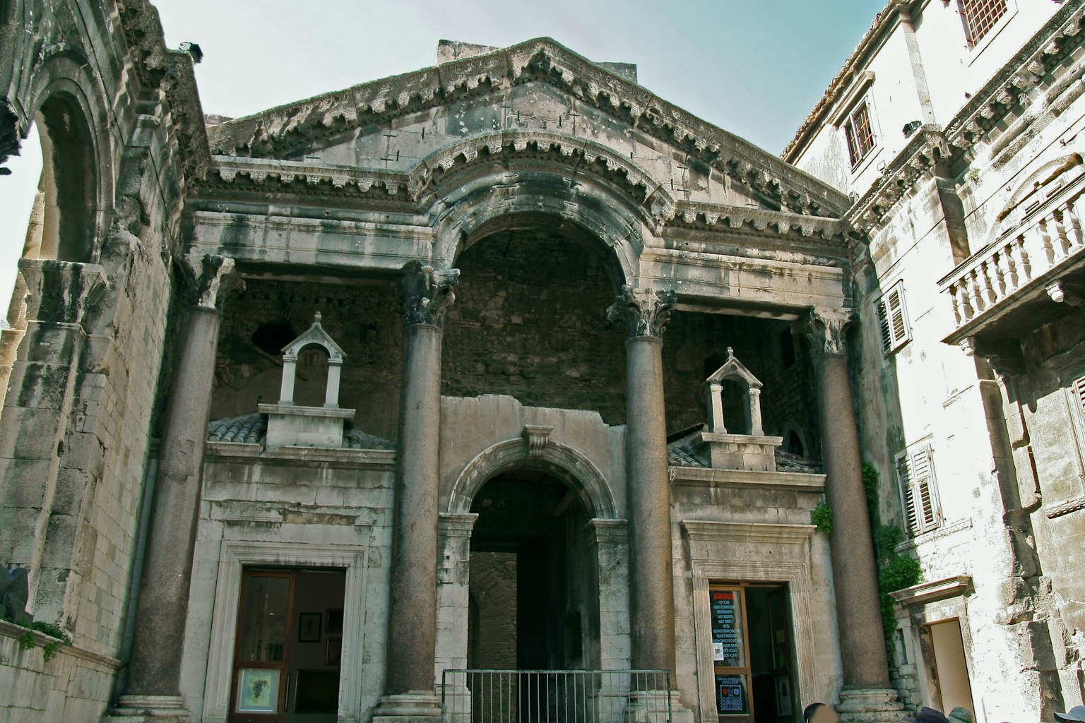Façade d'un bâtiment historique avec des sculptures anciennes et une entrée en arc