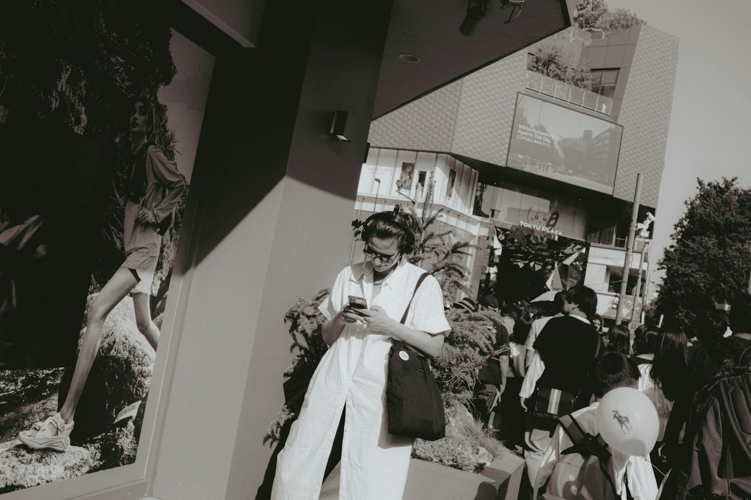 People using smartphones in a black and white urban setting with buildings in the background
