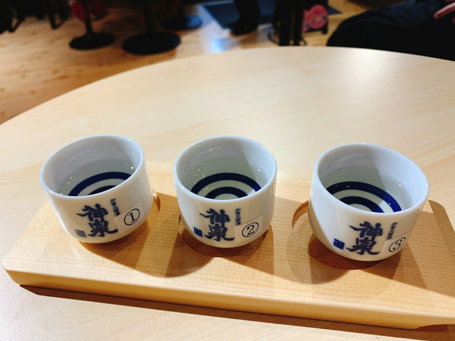 三個白色的清酒杯放在木托盤上