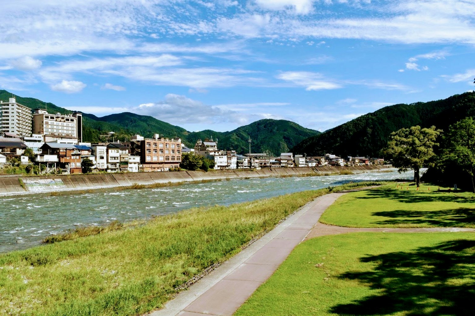 風景如畫的河邊景觀，藍天和綠色山脈
