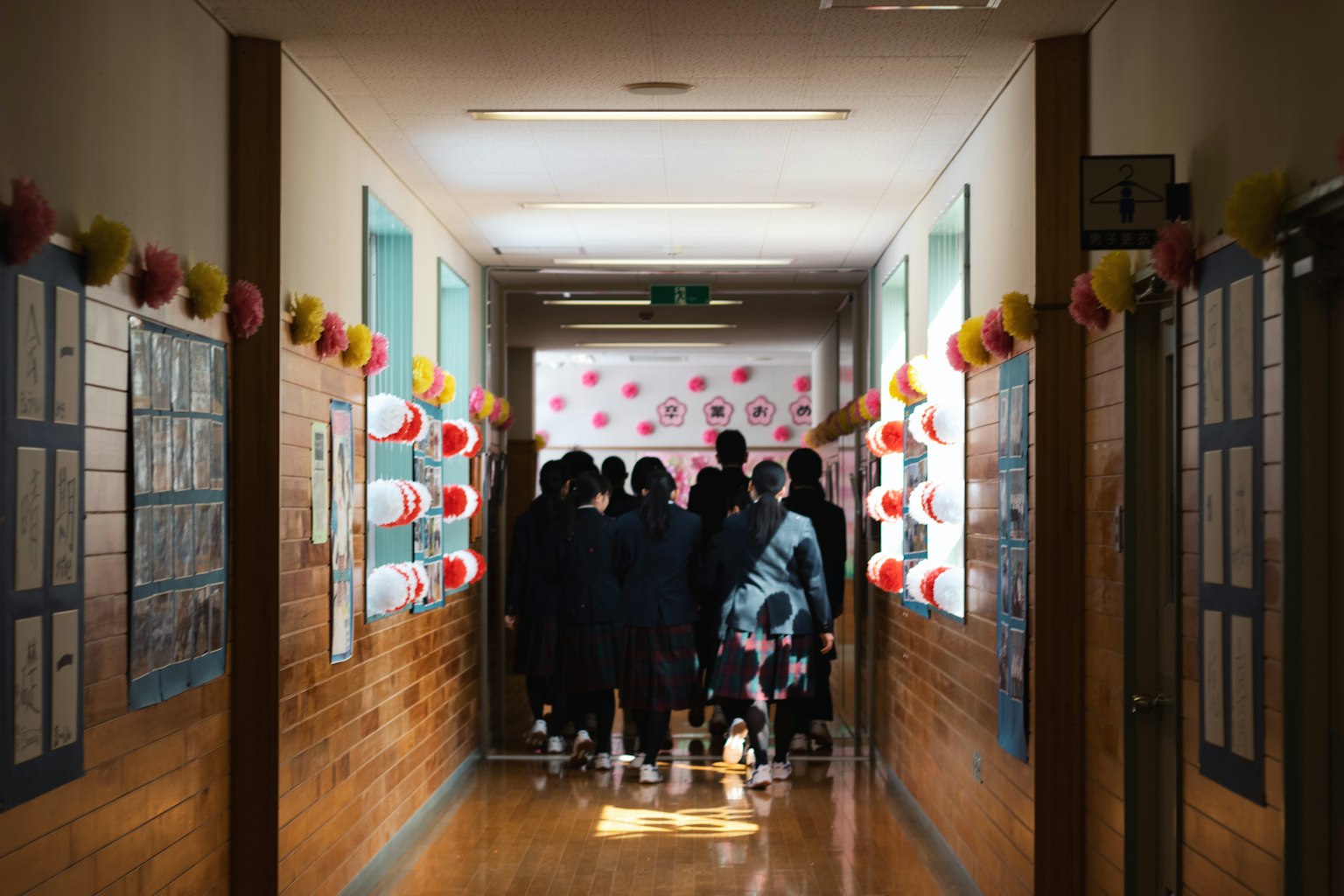 Estudiantes reunidos en un pasillo escolar con paredes decoradas