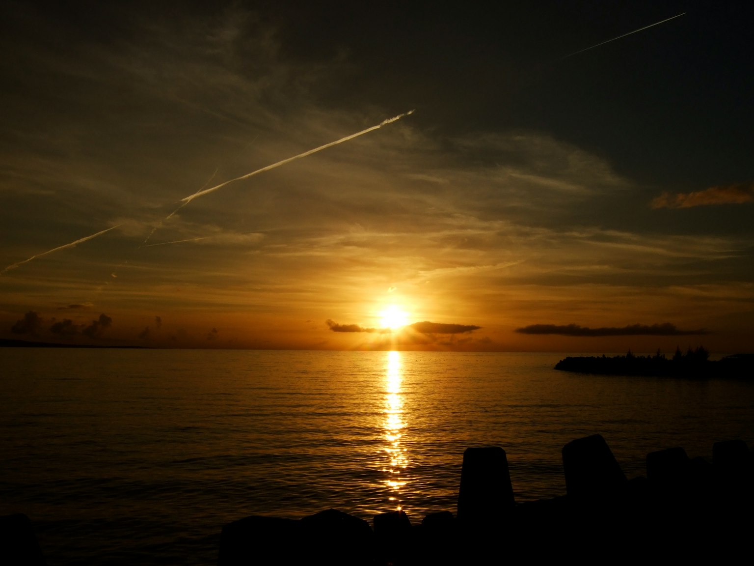 Tramonto che si riflette sull'acqua cielo arancione vibrante e mare calmo